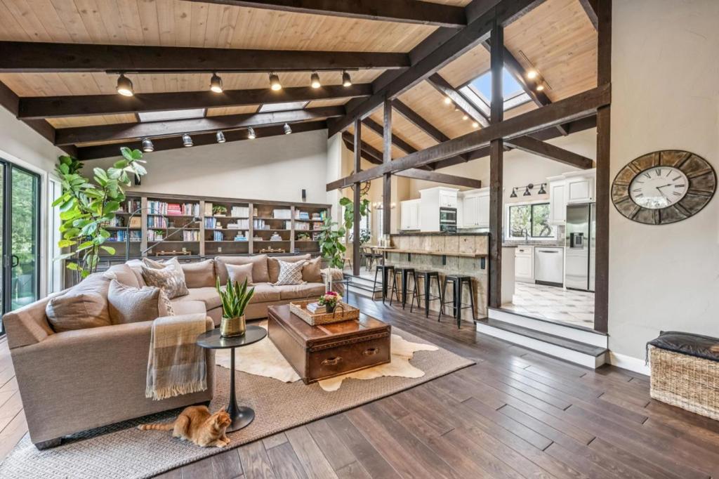 Nestled in the prestigious Woodside Hills, 61 Oak Haven Way is a private estate offering a rare blend of serenity, architectural volume, and thoughtful modern upgrades. Surrounded by majestic oaks on a beautifully landscaped 1.175-acre lot, the home is approached via a long paver driveway that offers privacy and presence. Fully remodeled in 2000 and tastefully updated since, the house includes wide-plank hardwood floors, updated fixtures, and a custom outdoor BBQ and entertaining area, ideal for indoor-outdoor California living. Inside, vaulted ceilings, skylights, and walls of glass fill the home with natural light. Three fireplaces and extensive built-ins add comfort and function. The expansive primary suite offers a fireplace, walk-in closet, private office nook, and a spa-like bath with a sunken jetted tub and cascading waterfall feature. The lower level includes a second en suite bedroom, two additional bedrooms and bathrooms, and ample storage. A three-car garage and generous circular driveway provide plenty of parking. Private and serene, yet only minutes to Sand Hill Road, Stanford, and downtown Woodside, Menlo Park, and Palo Alto this unique home blends nature, space, and easy access in one of Silicon Valley's most desirable enclaves.