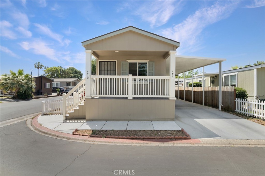 Welcome to 263 Camino Norte Unit 212! This newer construction mobile home built in 2021 is located in a lovely family park in North Chico! You will appreciate the fact that it offers a newer HVAC system, newer water heater and roof, along with modern bathrooms! The inside boasts laminate flooring, an open concept kitchen, and dual pane windows throughout. There is a guest bathroom alongside the first bedroom and a primary bathroom with a walk-in closet. Indoor washer and dryer hookups are located along the hallway. A darling fully enclosed front porch to sip your morning coffee along with white picket fencing around the flower beds that line the side yard. There is also a covered car port and a small gated area for a dog with an extra storage shed. Since this is a single wide manufactured home built in 2021, this property does qualify for financing! Properties like this don't hit the market with this kind of opportunity to finance a mobile home in a park! Call your realtor today!