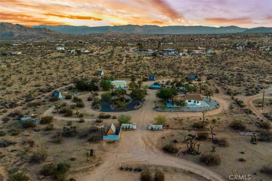 NEW PRICE! Seller is Motived to Sell!! Will provide property revenue upon request! Discover an extraordinary 5-acre income-generating desert retreat minutes from Joshua Tree National Park. This turnkey property combines luxury desert living with a successful boutique glamping business that grossed a significate amount in 2024 and was above the income of 2023. The contemporary main house features vaulted ceilings, natural wood beams, and a gourmet kitchen with expansive granite island. With nine bedrooms and stunning desert views through picture windows, it offers the perfect blend of comfort and natural beauty. A detached studio adds additional living space with its own kitchen, bedroom, bath, and attached garage. The property's hospitality infrastructure includes six framed structures, one the unique "Tin Can" and one studio apartment. With the right vision a buyer can rent out the house for additional income. Recent upgrades enhance the guest experience with a pool, spa retreat, bocce ball court, and renovated sun deck. Professional landscaping showcases mature palm trees and organically raised Joshua trees throughout the grounds. Multiple intimate spaces for relaxation dot the property, from poolside loungers to private daybeds. Guests can enjoy stunning sunrises, breathtaking sunsets, and stargazing under crystal-clear night skies. Recent improvements include renovated bathrooms, refurbished accommodations, and enhanced outdoor entertainment areas. This turnkey property presents a rare opportunity to own both a private desert sanctuary and a thriving hospitality

business. Perfect for entrepreneurs seeking to capitalize on the booming Joshua Tree tourism market while enjoying the serenity of high desert living. The established business infrastructure and proven income history make this an exceptional investment opportunity.