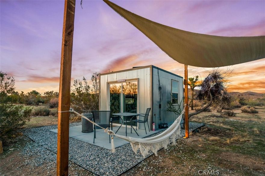 NEW PRICE! Seller is Motived to Sell!! Will provide property revenue upon request! Discover an extraordinary 5-acre income-generating desert retreat minutes from Joshua Tree National Park. This turnkey property combines luxury desert living with a successful boutique glamping business that grossed a significate amount in 2024 and was above the income of 2023. The contemporary main house features vaulted ceilings, natural wood beams, and a gourmet kitchen with expansive granite island. With nine bedrooms and stunning desert views through picture windows, it offers the perfect blend of comfort and natural beauty. A detached studio adds additional living space with its own kitchen, bedroom, bath, and attached garage. The property's hospitality infrastructure includes six framed structures, one the unique "Tin Can" and one studio apartment. With the right vision a buyer can rent out the house for additional income. Recent upgrades enhance the guest experience with a pool, spa retreat, bocce ball court, and renovated sun deck. Professional landscaping showcases mature palm trees and organically raised Joshua trees throughout the grounds. Multiple intimate spaces for relaxation dot the property, from poolside loungers to private daybeds. Guests can enjoy stunning sunrises, breathtaking sunsets, and stargazing under crystal-clear night skies. Recent improvements include renovated bathrooms, refurbished accommodations, and enhanced outdoor entertainment areas. This turnkey property presents a rare opportunity to own both a private desert sanctuary and a thriving hospitality
business. Perfect for entrepreneurs seeking to capitalize on the booming Joshua Tree tourism market while enjoying the serenity of high desert living. The established business infrastructure and proven income history make this an exceptional investment opportunity.