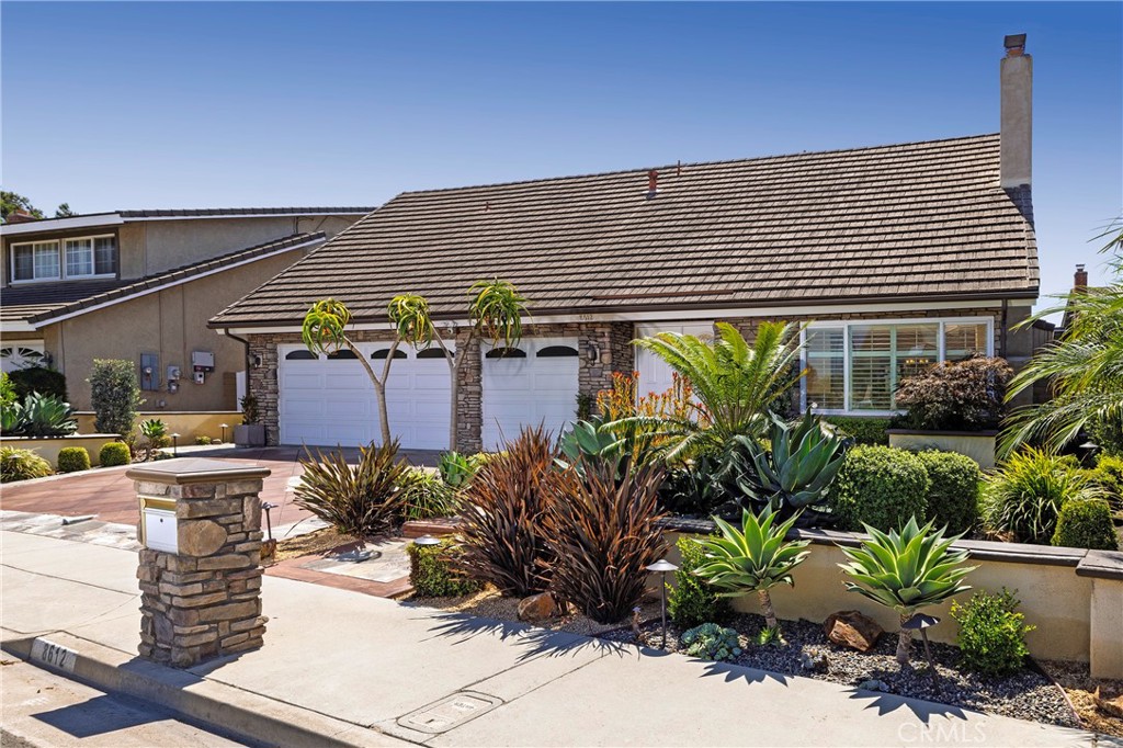 HUNTINGTON BEACH - Just one house away from the gorgeous grounds and ballfields of 17-acre Langenbeck Park in the heart of Huntington Beach, this lovingly maintained and upgraded home is ready to embellish your lifestyle. First impressions are memorable thanks to newer professionally designed hardscaping and landscaping, complete with a custom driveway and a variety of mature palms and plants, all complemented by upgraded stone accents. Double entry doors open to an impressive interior that spans approximately 2,348 square feet and offers four bedrooms and two- and one-half baths. The foyer is highlighted by a grand staircase and opens to a formal fireplace-warmed living room large windows and dramatic vaulted ceiling. Formal entertaining can easily continue in an elegant dining room with colorful stained-glass windows and a stunning chandelier. For casual occasions, the family room presents backyard access, crown molding, a fireplace with stone and wood surround, and a seamless flow to the kitchen. Whether it is mealtime or snack time, the fully appointed kitchen boasts a custom ceiling, granite countertops, wood cabinetry with a built-in pantry, a garden window overlooking the backyard, and stainless steel appliances including a Samsung refrigerator. Recessed LED lighting, woodgrain plank and tile flooring, smooth ceilings, ceiling fans and custom window treatments add an upscale aesthetic throughout. Baths are refined with tile shower surrounds and granite countertops, one bedroom features built-ins for a home office, and the attached garage accommodates three cars. Wainscoting enhances the primary suite, where homeowners will appreciate multiple closets with mirrored wardrobe doors and a customized bath with two sinks. Outdoor entertaining, gardening and simple relaxation is easily enjoyed in the backyard. In addition to its outstanding location mere steps from Langenbeck Park, this exceptional home is close to Perry Elementary School, Talbert Middle School, major shopping centers, countless dining opportunities, and downtown Huntington Beach’s pier and beaches.