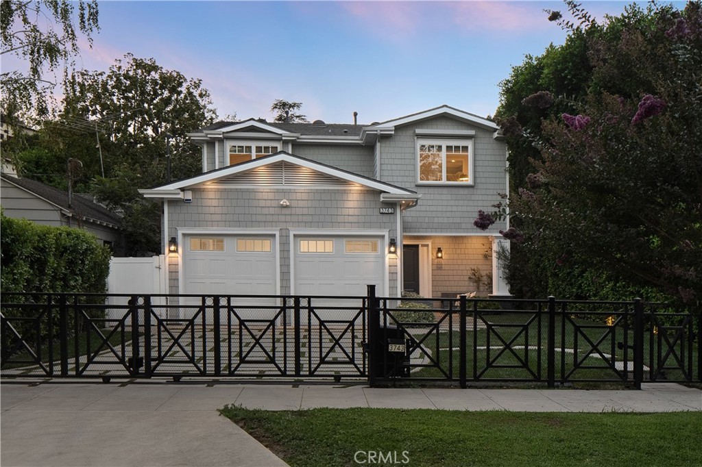 Nestled on a picturesque, tree-lined street in the coveted Silver Triangle neighborhood of Studio City, this privately gated Cape Cod-style home offers a warm, inviting interior that seamlessly blends timeless character with modern amenities. At the heart of the home lies the gourmet chef’s kitchen, complete with top-of-the-line appliances, an extended island with seating, butler’s pantry, separate walk-in pantry and bi-fold windows that open effortlessly to the backyard. The spacious, adjoining family room boasts an oversized accordion door that leads out to the covered patio, creating a seamless indoor-outdoor living experience. Outside, the serene backyard retreat is surrounded by privacy hedges and highlighted by a resort-style pool and spa, with a baja shelf and cascading waterfall feature. Completing the main level is a formal dining and living room, ensuite bedroom and powder bathroom. Upstairs, there are four generously sized bedrooms, three full bathrooms and a dedicated laundry room. The sophisticated primary suite offers a custom walk-in closet and spa-inspired bathroom that features a soaking tub, large rainfall shower and double vanity. Additional highlights include a state-of-the-art Savant smart home system, Enviroblind rolling security shutters on every window, high ceilings and custom cabinetry throughout, along with a gated driveway and finished two-car garage. Ideally located south of the Boulevard, within the coveted Carpenter School District, and just moments away from Studio City's Farmers Market, Fryman Canyon hiking trails, trendy restaurants, boutique shops and so much more.