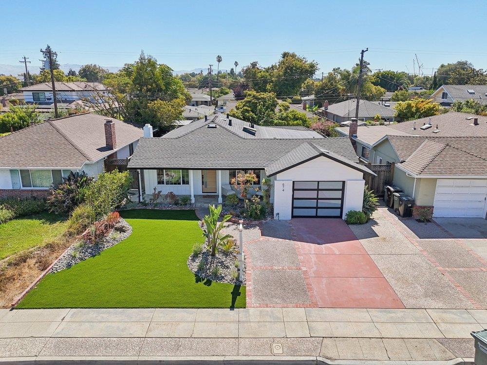 Sleek, fully reimagined modern compound in the heart of Sunnyvale - featuring a 3-bed, 2-bath main home plus a brand new 1-bed, 1-bath attached ADU. Just minutes from NVIDIA, Google and top tech campuses, this designer remodel blends style, function, and flexibility. The main home stuns with Level 5 smooth walls, wide-plank light oak floors, and a chefs Taj Mahal quartz kitchen with Euro-style cabinetry and Thermador appliances. Spa-like baths boast floor-to-ceiling tile, floating vanities, and LED-lit mirrors. A monolithic tile fireplace anchors the open-concept living room, flowing through multiple sliders to a redwood deck and turf yard. The ADU is equally refined, with its own full kitchen, luxe bath, in-unit laundry hookups, and dual sliders for seamless indoor-outdoor living. All new roof, HVAC, plumbing, dual-pane windows, electrical, epoxy garage, modern glass-panel door, and low maintenance professional landscaping. Turnkey luxury with income potential in a prime Silicon Valley location.