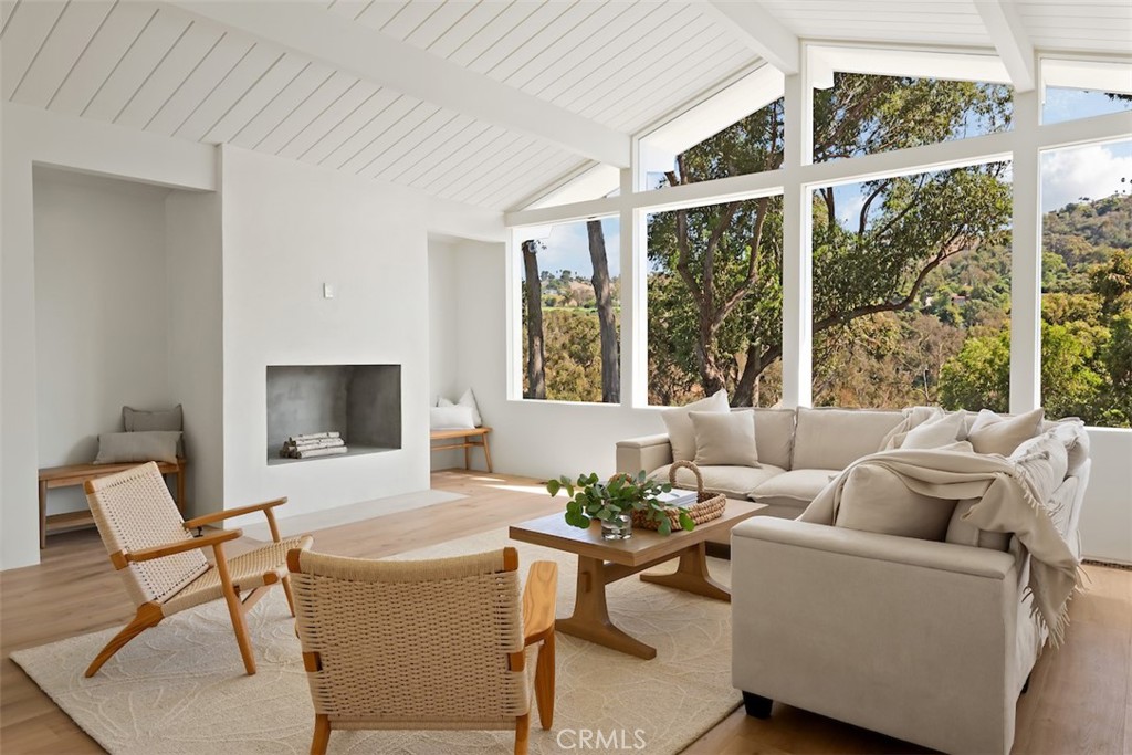 Nestled in the heart of the sought-after Valmonte neighborhood, Scandinavia meet California-an architectural home where every surface, finish and line has been meticulously considered. Newly rebuilt by BuildingGeeks Design Group, it is a study in custom calm and craftsmanship. On a quiet and peaceful, tree lined street, you will find the home is framed by towering eucalyptus trees and rolling lawns that lead to a private, enclosed grassy yard. A spacious patio with built-in bench seating provides the perfect backdrop for entertaining around a large outdoor table.
Step through the oversized custom Sierra Pacific front door into a dramatic great room defined by vaulted, beamed ceilings and oversized windows that capture treetop and hillside views. Wide-plank Garrison white oak wood floors flow throughout, complemented by 9-foot interior doors and a cozy fireplace. The dining area, anchored by a striking glass pendant, connects seamlessly to the chef’s kitchen. Outfitted with Marble countertops, a marble backsplash and custom cabinetry, the kitchen also features Thermador appliances, a five-burner cooktop, dual Bosch refrigerators and an oversized island with seating and prep sink—ideal for both everyday living and hosting. The primary suite is a true retreat with high ceilings, a wall of custom built-in closets, and French doors opening directly to the upper yard. The private bath offers dual vanities, marble counters and a custom Concretta shower treatment. Two additional light-filled bedrooms, featuring double closets, and including one with its own en-suite bath. A versatile flex space doubles as a home office or playroom, while a hallway niche houses custom cabinetry for washer and dryer. The oversized finished two-car garage expands the home’s usable space, complete with laminate wood flooring—perfect for a gym, playroom or studio. Set within one of Palos Verdes Estates’ most beloved neighborhoods, this residence balances thoughtful design and modern convenience with the warmth of Valmonte’s signature lifestyle: tree-lined streets, nearby trails, and easy access to the best of the South Bay. Alternate address: 2709 Palos Verdes Drive North.