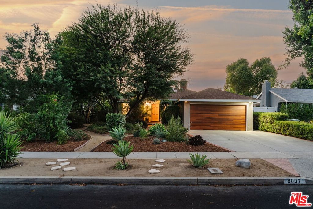This updated and lovingly cared-for mid-century ranch jewel greets you with its lush, drought-tolerant front yard alive with color, studded with lime, plum, and pomegranate trees, all enveloped by a glorious chilean mesquite. Step inside and bask in the sun-filled living room with picture windows, a wood-burning fireplace, as stunning refinished original oak hardwood floors flow throughout. Updates & energy savings: OWNED PAID OFF SOLAR, newer HVAC, newer roof and garage door, Level 2 EV fast charger, copper plumbing, attic insulation, nest thermostat, water filter, and an upgraded 200-amp panel to mention a few.The remodeled kitchen features stone counters, updated cabinetry with organizer pullouts, newer appliances, dining area and separate breakfast bar that opens to the living room, perfect for morning coffee or lively evenings. The floor to ceiling pantry and laundry room are located just off the kitchen, replete with storage. A thoughtful floor plan offers one bedroom up front with en suite bath, and two more tucked down their own private wing all with ample closet space and hall storage. The baths have been updated, including the full bath with dual-sink vanity and Rejuvenation finishes. The designer landscaped backyard reveals a sanctuary of fruit trees gathered around a flowing fountain, all growing in your own private garden of eden. Here, twilight suppers and mornings on the porch are memories waiting to be made. Summer BBQs under the twinkle lights await while there's still plenty of room for a pool or spa in your privacy-landscaped generous sized lot, not to mention the chic storage shed to store all your gardening needs. The finished 2-car garage offers flexibility of use for parking, a home gym, or studio, or explore your options as future rental as it has its own detached entrance (buyer to research options with LA City/LADBS). All just minutes from great grocery stores, shops, dining, and brand new theaters at Westfield Topanga & The Village (hello Costco!), yet tucked away in the serenity of its cozy Sunnybrae neighborhood. Welcome home!
