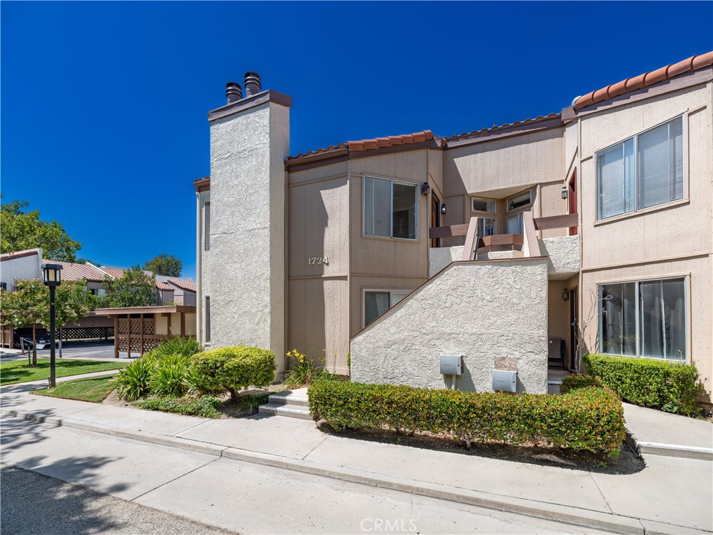 Welcome to this beautifully maintained top-floor condo in the heart of Simi Valley, offering a perfect blend of comfort, functionality, and community living. Located in the desirable Sinaloa Villas, this unit is tucked away in a peaceful, tree-lined setting surrounded by manicured lawns, winding walkways, and Spanish-style architecture. Step inside and you’re greeted by soaring vaulted ceilings, abundant natural light, and an open-concept living space ideal for both relaxing and entertaining. The living room features a cozy fireplace and flows seamlessly into the dining area and private balcony—perfect for morning coffee or alfresco dining with views of the lush grounds. The kitchen is clean and bright with crisp white cabinetry, ample counter space, and stainless steel appliances. The spacious primary suite includes a large closet, dressing area with dual vanities, and an attached bath. A generously sized second bedroom and full guest bathroom offer flexibility for guests, a home office, or family living. Additional highlights include in-unit laundry, central HVAC, wood-style flooring, recessed lighting, and assigned covered parking. Residents of Sinaloa Villas enjoy access to a wide range of resort-style amenities including a sparkling pool, spa, tennis courts, picnic areas, greenbelts, and a clubhouse. Conveniently located near parks, shops, dining, and freeway access, this is a fantastic opportunity for first-time buyers, investors, or anyone seeking a low-maintenance lifestyle in a well-kept community.