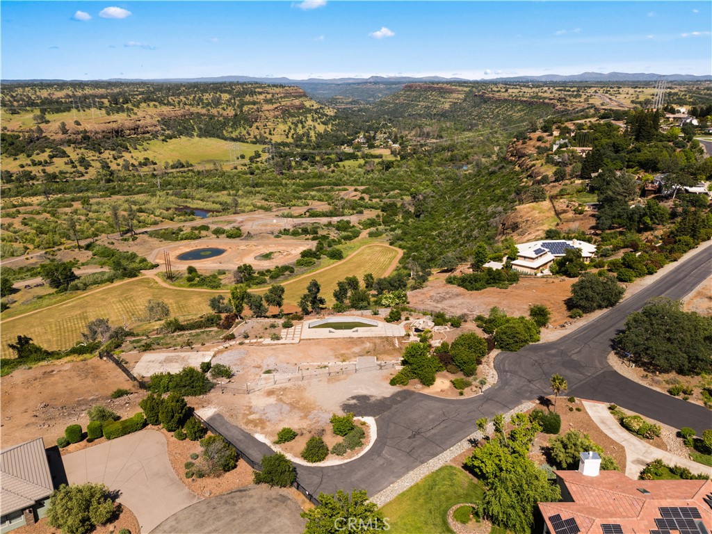 Welcome to a rare opportunity to own just shy of 1.5 acres in the prestigious Rocky Bluffs, a gated community perched above the valley floor in Chico. This fully usable lot isn’t your typical patch of dirt, it’s a thoughtfully enhanced slice of paradise with breathtaking views of the Canyon, City lights and unforgettable sunsets. Already on the property is a beautifully crafted Bob Hill pool, rock waterfall and koi pond, creating a serene oasis that feels like a private resort. Meander down the elegant concrete steps and walkway to the lower portion of the lot, where you’ll find separate landscaped areas to enjoy year round. A concrete pad ready for your vision is located on the pool level perfect for a sitting area, BBQ station, hot tub, or all of the above. With loads of nutrient-rich dirt already added, this lot is prepped and primed for your dream landscaping or garden. Located in Chico’s desirable banana belt, your plants will thrive year-round. Plus, the elevated position provides a refreshing break from the valley heat during summer months. Don’t miss your chance to build your dream home in one of Chico’s most sought-after communities. The prior home was a 5 bedroom, 5 bathroom boasting 4330 square feet. This is more than just a lot — it’s a lifestyle.