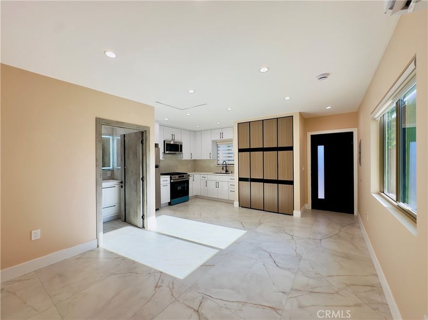 Open house: Thursday Oct 2, 5:30PM-6:00PM. The rent is $1,795, water and gas included. Brand-new, private studio ADU, at the front of the property, with its own gated entrance from the street. This modern home showcases a sleek design with a bright, open layout and recessed lighting throughout. The spacious living area includes a contemporary kitchen with stainless steel appliances, in-unit laundry, a luxurious bathroom, and a private outdoor space. Ideally located on a quiet, tree-lined street in a desirable pocket near Sherman Way and Woodman Ave. The large living room window overlooks the private yard lined with trees and fills the space with natural light, showcasing the expansive tile flooring with subtle marble veining. The kitchen features white cabinets, quartz countertops, a full backsplash, stainless steel appliances including refrigerator, gas range and built-in microwave, plus a deep sink with matte black faucet. A large built-in pantry with abundant shelving provides storage and houses the in-unit laundry. The well-designed floor plan offers space for a dining area next to the kitchen. The bathroom boasts full-height marble-style porcelain tiles, a frameless glass shower with rainfall and handheld showerheads, built-in bench, modern vanity with storage, LED lighted mirror, and sleek fixtures. The outdoor space is private and secure, with a gated entry leading to a landscaped yard bordered by lush hedges and trees. The yard combines grass with paved walkways, creating a comfortable patio area perfect for relaxation or outdoor dining. Water and gas are included in the rent. Electricity is separately metered and paid by the tenant. Easy street parking on a non-through residential street. Available immediately. Shown by appointment.