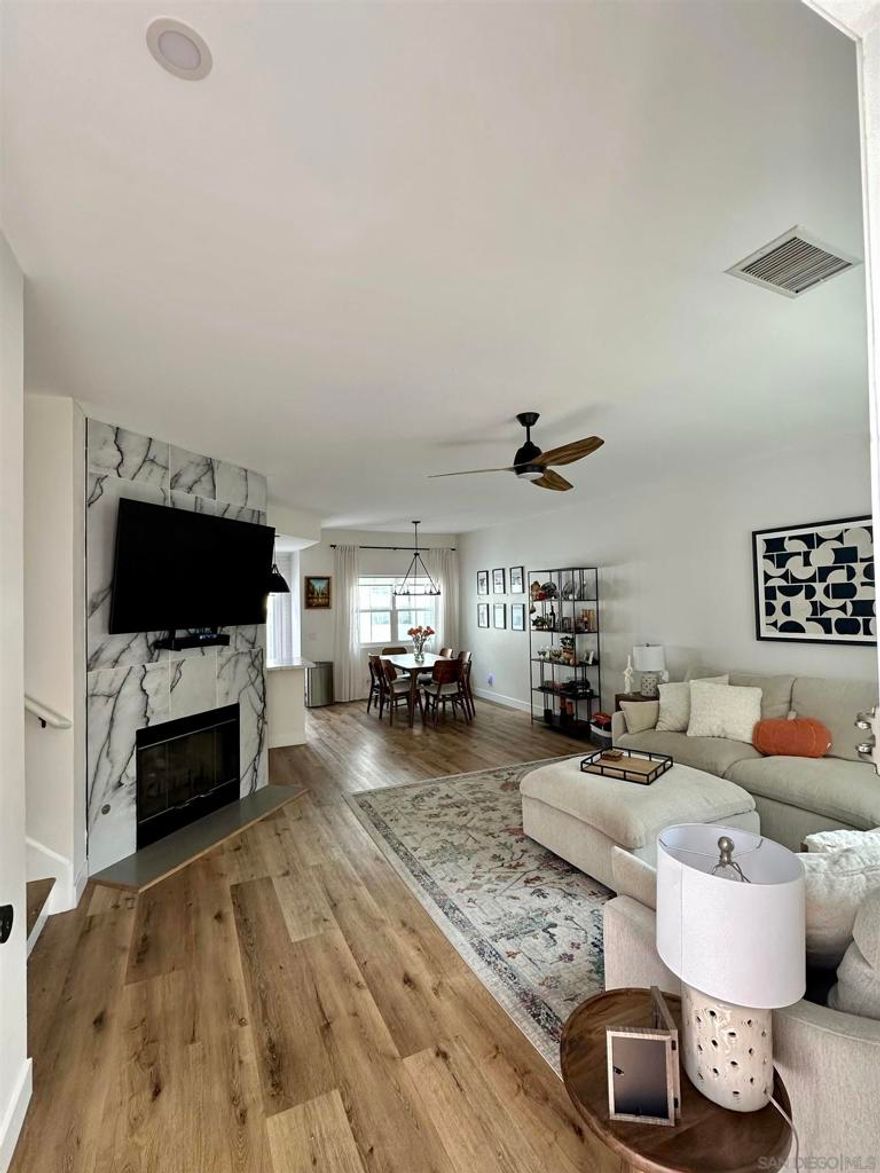 Live your best life at Scripps Townhomes! Imagine sitting on the idyllic rocking chair front porch with your favorite beverage soaking in the gorgeous San Diego weather all year round. Enter to gaze upon soaring vaulted ceilings over an open floor plan adorned by vinyl plank flooring throughout. Seamless daily living will be yours as the living room, dining room and kitchen flow effortlessly together. A stunning fireplace in the living room will be your favorite place to relax and unwind.  New Windows, Light filtering shades were added downstairs to keep the interior temperature comfortable. In 2022, the kitchen was re-imagined to feature crisp, white cabinetry, new stainless steel appliances, quartz countertops and modern accent lighting. Dine al fresco on the back patio. The half bath on the main level has been upgraded with modern flair. Both bedrooms are on the upper level, have upgraded ensuite bathrooms and recently had high-quality black out shades added. A built-in work center in the upstairs landing will help you stay productive when at home. The attached two car garage makes parking a breeze and a ceiling storage rack helps with the holiday decorations. 2023 Full size stacked washer/dryer conveys. A new roof was installed in 2021-2022 and the unit was fumigated in 2023. Scripps Townhomes is a serene, park-like community offering its residents tennis courts, a sparkling pool and a park. Great schools, shopping, dining and entertainment venues are nearby. This truly is an opportunity you do not want to miss!