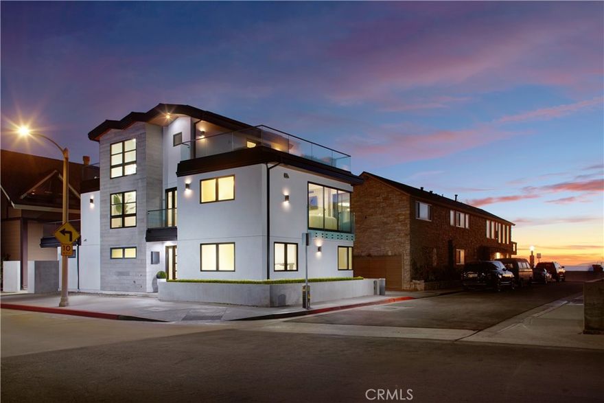 Just one row from the sand in a coveted Newport Beach location, this brand-new, never-before-lived-in ocean-view home presents the ideal blend of contemporary architecture, high-end appointments, and a versatile floorplan complete with an ADU. A premium corner lot provides abundant natural light across all three levels of this modern showplace. The main house features three bedrooms and two-and-a-half bathrooms, while the ADU includes one full bath for total living space of approximately 2,103 square feet. The first floor is home to two spacious bedrooms, an attached two-car garage with epoxy floor and glass roll-up door, and the ADU, which hosts a kitchen and a separate entrance with private patio. Take the dramatic staircase or the elevator to the second level, where an open living room and kitchen make entertaining a delight and display slideaway glass doors opening to beach and whitewater views. A linear fireplace lends enchantment to the space, and the kitchen shines with gorgeous porcelain countertops, a full porcelain backsplash, custom wood cabinetry, an island, tray ceiling with recessed and indirect lighting, and a convenient touch-operated faucet. Stainless steel Thermador appliances include a built-in refrigerator, drawer microwave and a six-burner range, while a Juliet balcony and versatile sitting area lend appreciated style. Relax on a wraparound deck in the primary suite, which hosts a freestanding tub, walk-in shower and two sinks. The third floor is all about relaxation and entertaining thanks to two Thor wine refrigerators, and two large decks with ocean, Catalina Island, city-light and Saddleback Mountain views. Preferred amenities include a rooftop solar array, outdoor after-beach shower, fresh landscaping, walls of glass, whole-house audio including the garage, instant hot water, tongue-and-groove wood planks under exterior eaves, and even a unique under-stairs pet hideout. Adjacent to Balboa Peninsula and a short stroll to shops and restaurants.