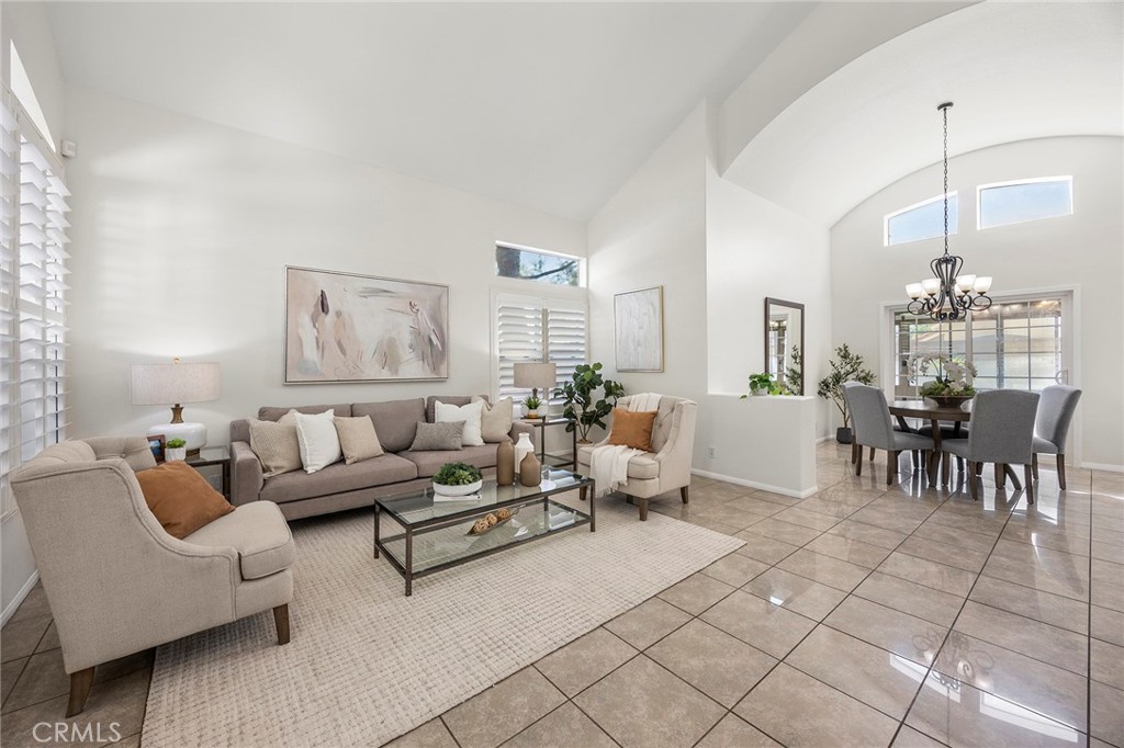 Welcome to this desirable residence that offers a neutral palette complimented by rich wood cabinetry and wrought iron accents. From the moment you arrive, the custom wrought iron entry door sets the tone for the stylish details found throughout. Step inside to the bright and open lower level, where gleaming tile floors and soaring ceilings immediately impress. An attractive archway gracefully frames the formal living and dining rooms, creating an airy ambiance. Plantation shutters lend a refined finish, adding warmth and sophistication to the living spaces throughout. The gourmet kitchen is perfectly appointed with a generous walk-in pantry, sleek granite countertops, and stainless-steel appliances, including an efficient six-burner gas range. A cozy dining counter and separate dining nook offers the perfect spot for casual meals, while the open layout flows effortlessly into the inviting family room with its charming fireplace—ideal for both entertaining and everyday relaxation. Downstairs also features a private bedroom suite, complete with double-door entry and an adjacent full bath, offering a comfortable retreat for guests or extended family. For added versatility, the oversized sunroom with a large storage closet, accessed through the dining room slider, can serve as a lively game room, a fitness space, or a play area for kids—the possibilities are endless. The graceful wrought iron staircase, highlighted by a skylight overhead, leads to the private sleeping quarters. The expansive primary suite offers a true retreat, featuring its own sitting area, dual granite vanities, a luxurious soaking tub, a separate shower, and a generous walk-in closet. Two additional bedrooms share a full hall bath, ensuring ample space for family and visitors alike. Step outside to enjoy the sun-filtered patio and the lush, wraparound lawn that provides a serene setting for outdoor dining, play, or quiet moments of relaxation. Beyond your doorstep, Brush Canyon Park awaits—just a short stroll away—with sprawling playfields, a fun tot lot, tennis, pickleball and basketball courts, and scenic walking trails, offering endless recreation in a vibrant community setting. This exceptional property combines sophistication, functionality, and comfort.