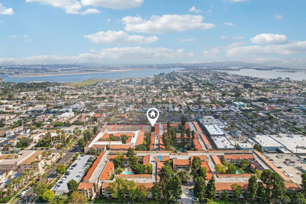 Soaring vaulted ceilings, clerestory windows, and an open floor plan create a bright, airy vibe in this spacious top-floor condo. The living room, dining area, and kitchen flow seamlessly onto an extra-long balcony with Bay Views! The updated kitchen features nearly new Samsung Smart appliances and smart-home compatibility, while the split dual-primary suite layout offers flexibility for guests or roommates. Move-in ready with abundant closet space, a reverse osmosis water system, and two secure parking spaces (one in the garage). Located in The Plaza, a beautifully landscaped gated community with a serene pond, two pools, two spas, tennis courts, a clubhouse, and multiple outdoor gathering areas. Just minutes from both the beach and the bay, you’ll enjoy the best of Pacific Beach living — from boardwalk strolls and water sports to vibrant dining, shopping, and nightlife.