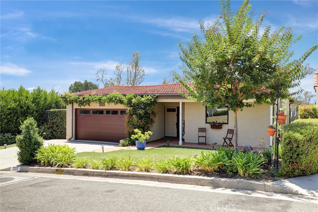 Beautiful, single-level ranch home in Fullerton's highly sought-after Hillcrest Park neighborhood! With stunning curb appeal, the spacious 3 bed, 2 bath home boasts a light-filled living room with vaulted open-beam ceiling, a brick fireplace, dual-paned custom wood windows and wood flooring throughout. The updated and bright kitchen has a large tile counter, newer appliances and plenty of cabinets for storage. Full bath is located in the hallway between the two guest bedrooms, each with dual-pane windows and closets providing great storage space. Well-sized primary bedroom with floor-to-ceiling sliding picture windows showing off city lights and seasonal sunset views. Primary bedroom has a large, walk-in closet and ensuite bath featuring a tile shower and dual sinks. The living room windows look out to a large covered courtyard that leads to a peaceful grass area with large Meyer lemon, lime and fig trees. You'll feel the good vibes from the moment you enter the front door. Welcome home!
