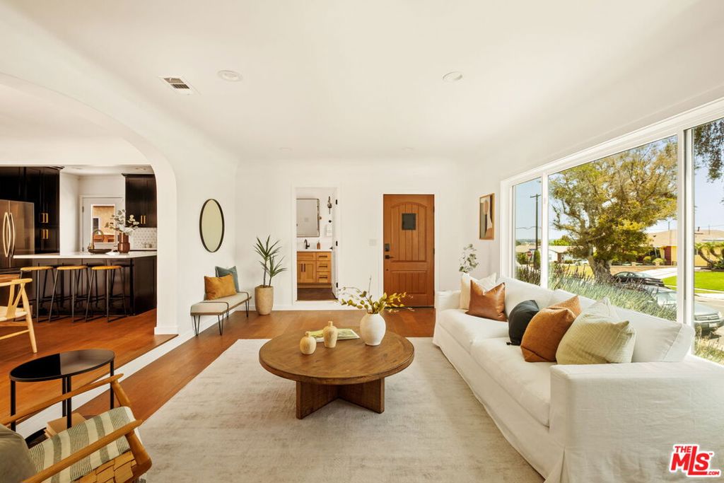 In the heart of sought-after View Heights stands this recently renovated three-bed, three-bath Spanish home with a one-bed, one-bath ADU. Blending old-world charm with modern technology, this smart home offers amenities such as remote-controlled shades, Tesla Powerwall, Tesla charging, Nest security system, keyless entry, smart thermostat, smart pet door, and more. Southern exposure provides ample sunlight all day and views of Palos Verdes. The open-concept living room seamlessly flows into the dining area and kitchen, all featuring new wide-plank oak flooring and custom light fixtures. The chef's kitchen is adorned with custom cabinetry, quartz countertops, a designer backsplash, and stainless steel appliances. Down the hallway, you'll find two guest suites and a primary bedroom with a spa-like bathroom featuring dual rain shower heads and a freestanding bathtub. French doors lead to a spacious patio, herb garden and grassy yard. A fully equipped back house with a separate entrance includes a full kitchen, living room, bedroom, and bathroom. All this, just a short walk to dining options such as Jon & Vinny's and Hilltop Coffee, and only ten minutes to hiking trails and Marina del Rey.