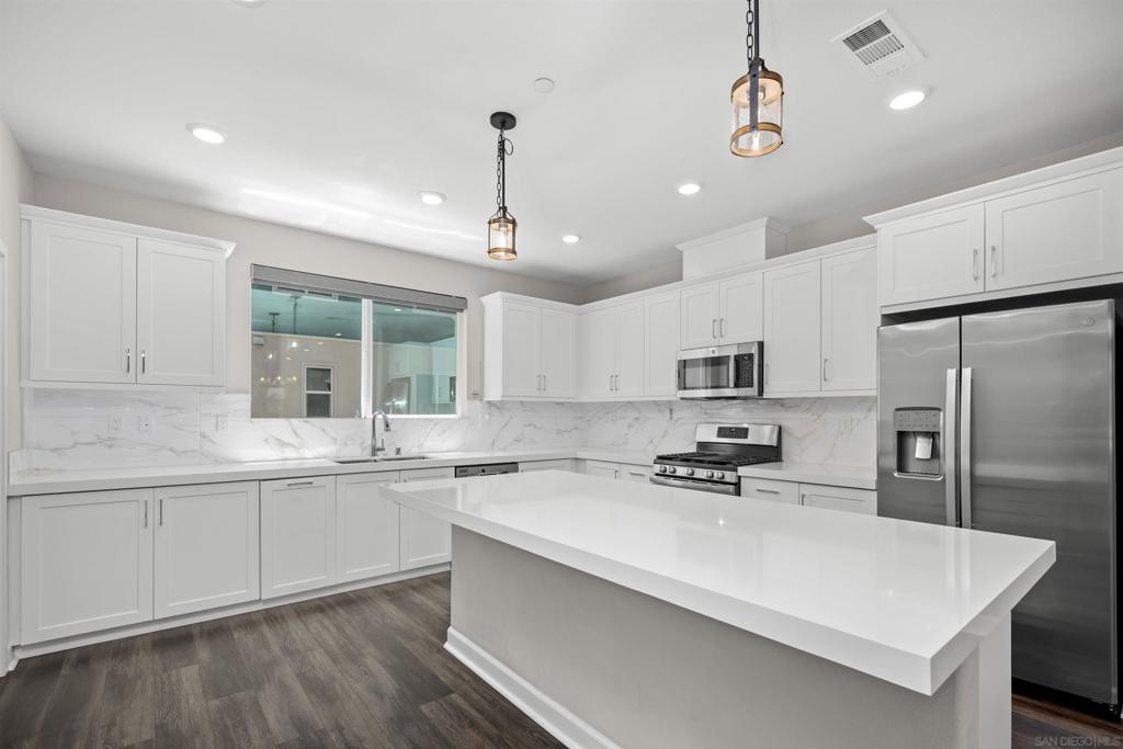 *Over $47k in builder upgrades!* Step into modern luxury in this beautifully upgraded tri-level townhome located in the highly desirable Vibe at Millenia community in Chula Vista. Featuring 4 bedrooms and 3.5 bathrooms, this newer construction home includes over $47k in thoughtful builder upgrades, such as custom lighting in the kitchen & dining area, creating a stylish & elevated ambiance throughout, along with luxury vinyl flooring! The heart of the home is an open-concept living area that smoothly connects the upgraded kitchen, dining, & living rooms, making it ideal for entertaining or enjoying everyday comfort. This fully integrated smart home easily links to the security system, front door, doorbell, thermostat, lights, & more, allowing full control from your phone or smart device. The home is also pre-wired for surround sound & a security system, providing both convenience & peace of mind. Enjoy motorized window treatments throughout, strong connectivity with built-in WiFi access points on all three floors, & energy savings with paid-off solar panels that will transfer to the new owner at closing. Upstairs, you’ll find spacious bedrooms with ample storage, including a large primary suite with a private en-suite bathroom. Each room is filled with natural light, features well-designed layouts, & provides flexibility for family, guests, or a home office. Additional highlights include a two-car garage, a tankless water heater, & access to community amenities such as a resort-style pool and spa, BBQ & firepit areas, & a children’s playground, all situated in a well-maintained neighborhood with low HOA fees. Centrally located, this home is just minutes from grocery stores, top-rated schools, local parks, restaurants, shops, and all the conveniences of the Millenia lifestyle. This is your chance to own a move-in-ready, energy-efficient home in one of Chula Vista’s most vibrant and walkable communities.
