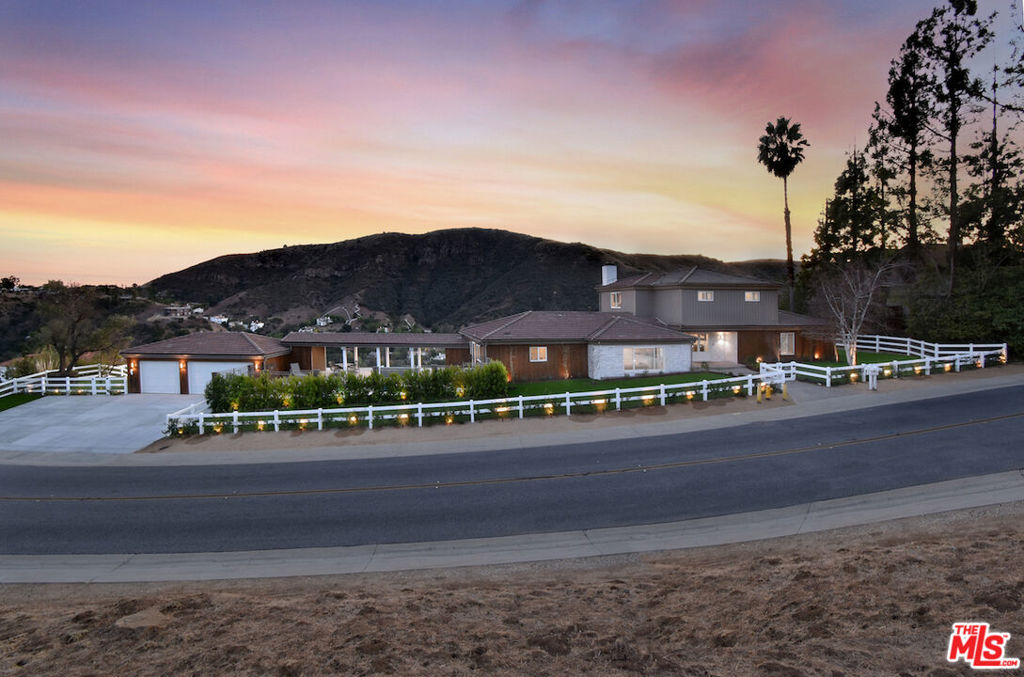 VIEW VIEW VIEW! New Price improvement! $300,000 in price reduction! Set in the prestigious gated community of Bell Canyon is this fully remodeled Traditional home is perched atop a 1.38-acre promontory, offering stunning canyon views from nearly every room. Every detail of this residence has been thoughtfully remodeled, blending timeless charm with modern luxury for a truly turnkey living experience. The open floor plan is perfect for both entertaining and everyday living. The expansive living room, with glass walls, opens to a private terrace where you can take in Bell Canyon's tranquil evenings. Adjacent is the family room, complete with a wet bar, flowing into a chef's kitchen. This fully remodeled space includes custom new cabinets, a water filtration system, and an expansive breakfast nook. The formal dining room, framed by sunset views, offers a versatile setting for casual or formal gatherings. Key Upgrades Include: * New Roof, Gas Line, Plumbing, & Electrical Systems (new electric panel). * New Garage Doors, epoxied floors & approved plans for a 768 Sq.Ft. ADU above the garage * Converted one garage space into a fully functional office. * New Glass Railing on the primary bedroom balcony and a remodeled primary bath with steam shower, custom tiles, heated marble floors, heated towel bar, Toto toilets, Rohl plumbing fixtures, and luxurious finishes. * Completely remodeled Guest bedroom bath and powder room. * New Paint, Drywall, and Exterior Wood/Stonework, along with freshly laid turf, slabs, and rock detailing for a polished exterior. * Renovated saltwater Pool & spa w/new equipment offers a serene outdoor escape. * 5 to 6 parking spaces in the driveway. The home's layout includes three downstairs bedrooms, two with direct patio access, and an upstairs primary suite with private viewing deck, custom-built closets, and a spa-like bathroom. Custom cabinetry throughout enhances functionality. Outdoor living includes covered patio & multiple terraces, surrounded by lush landscaping. The home also features a tankless water heater & whole-house water system for efficiency This property is a rare opportunity to own a meticulously updated home with modern amenities in a secure, private setting. Bell Canyon offers 24-hour gated entry, equestrian center, tennis courts, a fitness center, and year-round community events. Served by the award-winning Las Virgenes School District.