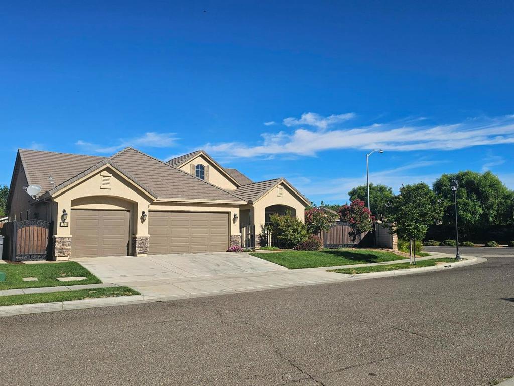 Welcome Home to 1703 Cobblefield Lane. This stunning home is located on an oversized 11,057 Sq Ft Lot on the edge of town. Easy HWY access. With a spacious 3,129 sq. ft. living area, this residence offers four bedrooms and two full bathrooms, including a primary suite with a luxurious tub featuring jets and a walk-in closet. The kitchen is a chef's delight, equipped with granite countertops, a pantry, dishwasher, and 220 Volt outlet. The kitchen seamlessly flows into the family room, perfect for entertaining. High ceilings, vaulted ceilings and plantation shutters add a sense of grandeur to the home, while double pane windows and a tankless water heater contribute to energy efficiency. The flooring consists of carpet and tile, and a cozy fireplace enhances the living area. Enjoy the convenience of an inside laundry area with both electricity and gas hookups. The property includes a security gate, patios, garden shed, and workshop. Variety of fruit trees. Pomegranate, Persimmon, Lime, Peach, Apricot, Olive and more. Additionally, this home features a three-car finished garage and a double gated entry on the side for your boat, RV and toys, providing ample storage and parking. City of Los Banos says with permit you can build an ADU on this property. Don't miss this dream house!