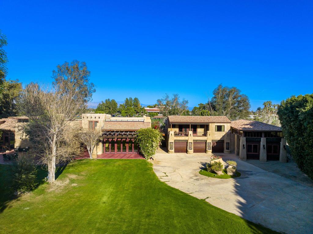 Welcome to The Adobe Hacienda, a private 1.5-acre gated estate in the heart of Rancho Mirage, offering unmatched character, artistry, and tranquility. Designed by renowned architect Jim McIntosh, this 8,990 sq ft custom-built compound features 2 spacious bedrooms, a library, grand kitchen, multiple living areas, 2 dining areas, and 3.5 bathrooms in the main home. Three detached casitas/studios--each with their own living quarters--offer ideal spaces for guests, artists, or a private retreat.Crafted with 2-foot-thick rammed-earth walls and red wine-pigment-stained floors, this estate blends strength and sustainability with beauty. Imported design features include stained glass from Amsterdam, hand-forged ironwork from London's Barclays Bank, and sinks and doors from England's Cotswolds. A powder room ceiling made of peacock feathers and hand-painted details throughout elevate every space with whimsy and soul.Lush courtyards, romantic balconies, a saltwater lagoon-style pool, bird aviary, and custom storybook-inspired garden walls invite outdoor living, while panoramic mountain views surround you. The Adobe Hacienda is a soulful fusion of European elegance and desert serenity--an architectural gem unlike any other.