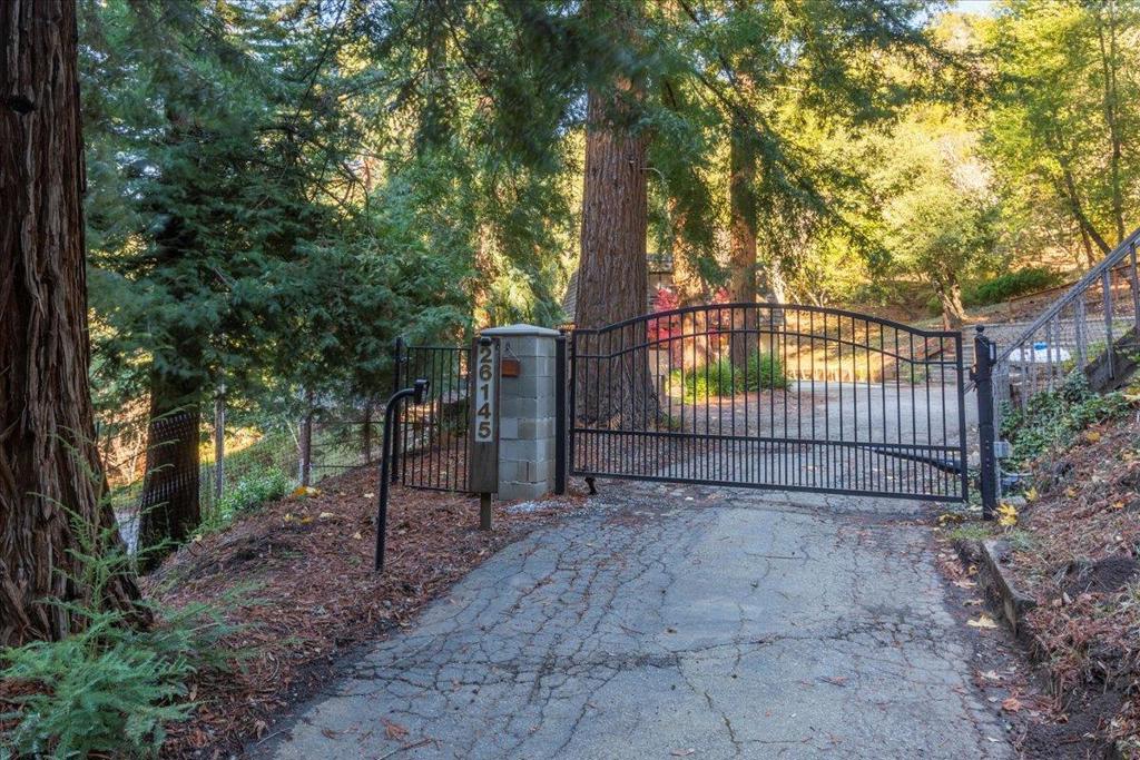 Escape to the enchanting Los Gatos Mountains! This serene retreat is nestled among majestic oaks and redwoods on a .94-acre lot. The open floorplan offers wide views, with an expansive wrap-around deck for seamless indoor/outdoor living. Inside, hardwood floors grace the downstairs, and plush new carpet adds comfort upstairs. The kitchen features cherrywood cabinets with pull-out shelving, granite counters, and stainless steel appliances. Baths are nicely renovated. Cozy up by the fireplace on chilly evenings. The primary suite offers a walk-in closet and a spacious balcony for morning coffee and a "moment of zen". Other updates include newer central a/c and water heater, updated furnace, newer retaining walls & porch, and a watertight roof clearance. Defensible Space, Septic, and Low Flow Fixture clearances are all done, too. The terraced landscape includes a play area, garden beds, a chicken coop (laying hens stay), and a workshop/storage shed/possible office wired with electricity. About 20 minutes from Downtown Los Gatos and 30 minutes from Santa Cruz beaches, with easy access to Highway 17 via Summit Rd. Enjoy mountain living with top-rated schools, including Los Gatos High (buyer to verify schools). Experience the magic of this idyllic retreat!