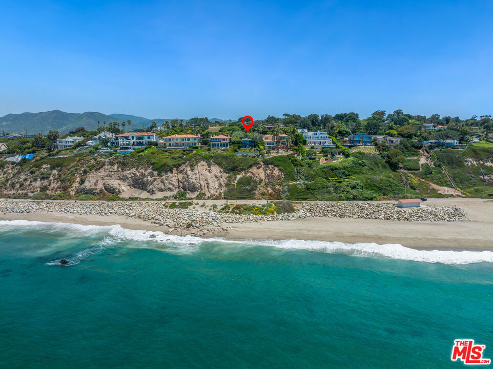 Perched on Birdview bluff above scenic Westward Beach, this light-filled contemporary residence has the amenities of a vacation resort and the deeply rewarding comforts of home. Commanding sweeping ocean and island views, the approximately 0.57-acre property is richly landscaped and terraced, with balconies, decks, and patios. From the gated entry, the long drive passes a pickle ball court with stadium lighting and a swimming pool and spa in a very private garden setting with a wide flagstone pool deck for lounging. The drive ends in a motor court with ample guest parking, and the home opens to reveal breathtaking ocean views from a stunning great room. With cathedral ceilings, a corner fireplace, a window seat, beautiful wood floors, and handsome built-ins, the great room has expansive ocean-view windows and glass doors that slide away to provide seamless access to the wraparound deck for al fresco dining and entertaining. A lovely dining area shares the views, and the professional chef's kitchen is just beyond, featuring an island with bar seating, marble countertops, a beverage cooler, quality appliances, and a wide garden-view window above the sink. Off the kitchen is a mud room with a door to the side garden where there is a water feature and an outdoor shower. Also on the entry-level are two bedrooms, a full bath, and a powder room. Steps near the front door lead down to the ocean-view primary suite, which occupies the entire lower level. This private haven has a sitting area with a fireplace, closet, generous built-ins, and a wall of glass opening onto a partially shaded patio and gorgeous ocean views. The primary bath, which also has ocean views, has a door to the backyard as well as access to an additional storage/closet/laundry room. On the ocean side of the house, the backyard provides numerous options for entertaining and relaxation, with a large flagstone patio, a lawn, a firepit area with seating surrounded by a mature succulent garden, and a deck with sitting areas that overlook the beach, the waves, and views to the horizon. The home has central air conditioning, a two-car garage, outdoor irrigation, and a full complement of smart-home features, including automated window shades, Sonos sound, and security. This is an estate of exceptional quality and comfort. Available for lease $40,000 per month.