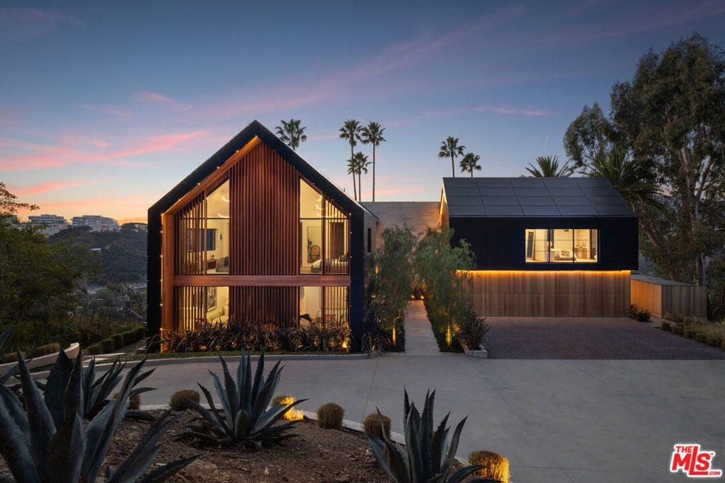 Introducing FRAME, an architectural compound by AADS, sited on over 3.5 lush acres in lower Bel Air with 270-degree Ocean, City, and Getty views. Gated and private, a 250-foot driveway leads to an oversized motor court, revealing a dramatic Scandinavian-inspired gabled roofline and exterior with resort-like grounds. A procession of pepper trees forms a natural colonnade, creating a moment of transition. Inside, a soaring 30-foot atrium introduces volume, crowned by a custom concentric Bover chandelier. Double arches present a deliberate pause before leading to the sunken living room, where wood floors seamlessly meet a sculptural travertine fireplace with a discreet built-in motorized TV. The effect is one of intimacy within expansiveness, a rare and studied composition in a home of this scale. A custom planter brimming with ZZ flora acts as an organic partition and softens the division between inside and out, a subtle nod to the estate's biophilic design. The Molteni & C Dada kitchen, a triumph of Italian craftsmanship, features book-matched Calacatta marble, a PITT stovetop, double islands offset rather than stacked, breaking convention for a more sculptural form, and multiple seating areas. Beyond, a fully appointed chef's pantry awaits, a complement ideal for dinner parties and events. The bar area pairs travertine surfaces with open shelving framed by smoked ribbed mirrored glass, recessed walnut panels, and LED-lit shelving designed to reveal rather than display. Adjacent lies a temperature-controlled wine closet, a quiet ode to oenophiles, with space for 190 bottles to age gracefully. Upstairs, tranquility reigns. Each of the home's en-suite bedrooms was designed to experience a symphony of natural light and the surrounding landscaping. The primary suite, with its center-pivot windows and private balcony, feels like a gallery to the skyline. Dual bathrooms, clad in floor-to-ceiling travertine slabs, evoke the monolithic beauty of the Getty; their floating vanities, designed as seamless extensions, elevate everyday rituals into luxurious indulgences.The detached guest house, spanning over 3,400 square feet, is a dedicated wellness sanctuary. Two south-facing en-suite bedrooms capture uninterrupted sunlight, while private access leads to a glass-enclosed fitness pavilion with a gym, sauna, steam room, and massage suite, all opening to a wraparound terrace overlooking the storied Moraga vineyards. Outdoors, the landscape is composed with the same precision as the interiorsa travertine infinity pool extends toward the horizon, while a private tennis/basketball court, large grass lawn, BBQ, and fireplace complete the grounds. At the estate's edge, a 40-foot mahogany hangar garage door, engineered with a moment frame structure, creates a seamless, uninterrupted facade. FRAME, located at 879 Linda Flora Drive, offers an incomparable blend of thoughtful design, organic elements, and architectural innovation. Every detail has been meticulously composed, creating a legacy of design and aspiration in the hills of Bel Air.