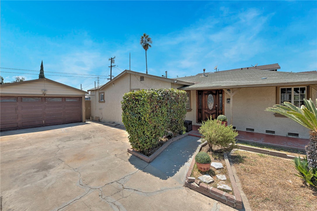 This charming 2-bedroom, 1-bath home offers a fantastic opportunity for both first-time homebuyers and seasoned investors. Situated on a spacious lot with a huge front yard, this delightful property provides both privacy and excellent curb appeal. An extra-long, wide driveway leads to a welcoming front porch, providing ample parking for RV and many vehicles. Inside, you'll find a spacious living room with a beautiful wood beam ceiling and recessed lighting, along with a formal dining area. The country-style kitchen is well-appointed, featuring a large pantry, generous counter space, and a lovely breakfast nook. Both bedrooms are generously sized, and the large, upgraded bathroom boasts a modern shower and stylish vanity. There's also a double-door hallway closet for added convenience. The backyard is designed for easy maintenance and offers plenty of space for outdoor entertaining. Laundry hookups are located inside the garage. The large two-car garage is perfectly positioned with direct access to a wide and clean alley, presenting an excellent value added ADU opportunity. Located on a quiet street in a desirable neighborhood, this home is within walking distance of shops and restaurants, and offers easy access to the 105 and 710 freeways. Let's make this wonderful property your sweet home!