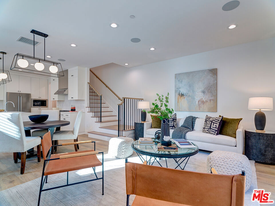 Discover a beautifully designed new residence in the sought-after Rancho Park / Cheviot Hills community. Built by Thomas James Homes, this two-story home within a modern duplex blends comfort, style, and everyday convenience. The main level offers an open and inviting layout, where the living room, dining space, and kitchen flow effortlessly together. The chef's kitchen is equipped with a walk-in pantry, a spacious island with bar seating, and sleek pendant lighting, perfect for casual meals or entertaining guests. Just beyond the dining area, glass doors open to a private patio, creating a seamless indoor-outdoor lifestyle. Upstairs, three secondary bedrooms share a full bathroom and hallway linen cabinetry, while the laundry closet with side-by-side washer and dryer adds functionality. The primary suite serves as a private retreat with a spa-like bathroom featuring dual sinks, a walk-in shower with a built-in seat, and a large walk-in closet. Additional highlights include a tandem garage with EV charger wiring and direct entry, a drop zone with a bench for everyday organization, and extra driveway parking. Even better, the property is equipped with solar panels, helping keep electricity costs significantly lower. Set in one of West LA's most desirable neighborhoods, this newly built home offers modern design paired with an unbeatable location. A perfect blend of thoughtful detail and contemporary living, ready for its next resident.