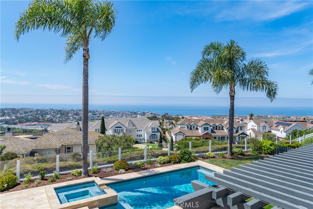 This light-filled home is set on a premier San Clemente terrace, with sweeping 180-degree ocean, Catalina, and city light views in a refined coastal setting. This private enclave is a thoughtfully designed 4409 sq ft estate, featuring 5+ bedrooms and 6 bathrooms. A Dakota stone pathway leads past Cypress and a majestic olive tree, setting the tone of timeless European influences with quintessential Southern California style. Inside, a voluminous entryway with Versailles-pattern limestone and custom ironwork handrail, leads to vaulted ceilings, carved stone fireplaces, and generous living spaces with seamless indoor-outdoor flow. The sunny attached casita, with ADU possibilities, has a private entrance, full bath, and temperature-controlled wine room that is ideal for guests, creative use, wine pairing, or a wellness studio. The panoramic ocean views are on full display from most every room.
The eat-in family kitchen is cooking, showcasing top-tier appliances, a statuary marble island, honed black marble countertops, a large pantry and open wood shelving. Even the kitchen sink has amazing views. Off of the kitchen is a den/tv room with an amazing hand carved fireplace, wine fridge and more sit down ocean views.
A second, main-level guest suite with full bath adds flexibility for all. The formal living room soars with 22 foot ceilings, walls of glass, and another amazing hand carved stone fireplace. The dining room has perfect ocean views.
The primary suite is a true retreat with commanding ocean views a custom built walk-in closet, and glass doors that open to a breathtaking sundrenched deck with panoramic ocean views. The primary bath is a luxurious retreat with custom stonework, and a soaking tub with an ocean view.
Outside, enjoy an expansive French limestone patio with French limestone columns under a huge trellis. Towering palms frame the solar heated French blue pool with waterfall spa and the custom Dakota stone and limestone finished fireplace. A sleek glass back fence offers unobstructed views. The teak outdoor shower adds a luxurious resort touch.
Located at the end of a quiet cul-de-sac within the prestigious guard-gated community of Marbelhead, this home offers a 3-car garage and 3 additional parking spaces in the driveway. Moments from world-class beaches, restaurants, shopping, schools, and recreation.
This is a rare coastal-soul offering combining elegant craftsmanship, ocean view serenity, and resort-caliber amenities.