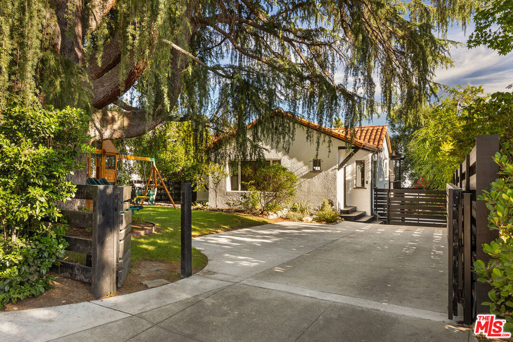 Unite in preserving the charm and architectural heritage that makes Altadena a unique jewel of Los Angeles County. For those looking to return, this is a heartfelt invitation to be at the forefront of efforts to restore, preserve, and rebuild the beloved community. Welcome to 956 Parkman Street, a beautiful Spanish Revival home in the Northeast Altadena area. The meticulously renovated three-bedroom, three-bathroom home features stunning finishes throughout. Enjoy hardwood floors, beamed ceilings, and plenty of natural light from dual-pane windows, all within an inviting open floor plan. The gourmet kitchen is ideal for hosting, equipped with custom cabinetry, Thermador appliances, quartz countertops, a central island with a farmhouse sink, and a spacious walk-in pantry. The primary suite features an en-suite bathroom with a custom vanity and a lux walk-in shower, accented with terrazzo-style tile work. The lower level offers a versatile third bedroom and family room, ideal for a mother-in-law suite, guest quarters, or a home music studio. The outdoor space is perfect for entertaining, featuring an A-frame playhouse that's suitable for all ages. Plus, enjoy breathtaking city lights and ocean views from the upper patio, a great place to call home.