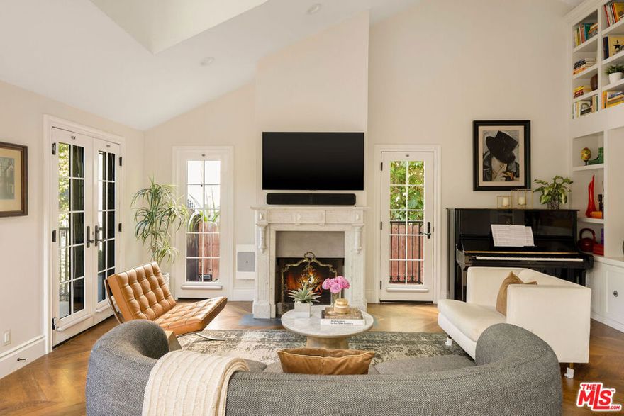 Rebuilt and reimagined to perfection, this rare single-level four bedroom residence embodies timeless elegance with soaring 15-foot ceilings, abundant natural light, and a seamless blend of classic craftsmanship and modern sophistication. Completed in 2023, every detail has been curated with the highest quality finishes and thoughtful design. Step inside to a luminous open floor plan featuring chevron white oak hardwood flooring, multiple skylights, custom millwork, and Forbes & Lomax designer light switches. The chef's kitchen is a true centerpiece with a dramatic 15-foot ceiling,  Jenn-Air professional-grade appliances, dual appliance garages, pot filler, and an oversized island ideal for entertaining. The living room exudes character with original 1920s stained glass, a marble fireplace mantel imported from Europe, and built-in library shelving reaching to the ceiling.  The primary suite offers vaulted ceilings, dual skylights, a gas fireplace, French doors with a Phantom screen system, and a custom walk-in closet. The spa-like primary bath showcases Bardiglio and Carrara marble floors, a clawfoot tub, oversized shower, and an antique door with a diamond-leaded window. Three additional bedrooms each with abundant storage and bespoke details share beautifully appointed bathrooms featuring Calacatta Viola marble and Phylrich fixtures.  Outside, enjoy a serene private oasis with new hardscape and soft scape, diamond-pattern pavers, a motorized driveway gate, and lush privacy hedging.  Additional features include Doorbird entry, EV charging, custom shed with power, and built in speakers throughout.  Perfectly situated mid-block on one of West Hollywood West's most coveted streets, this home offers an unparalleled lifestyle steps from the city's best dining, shopping, and entertainment.