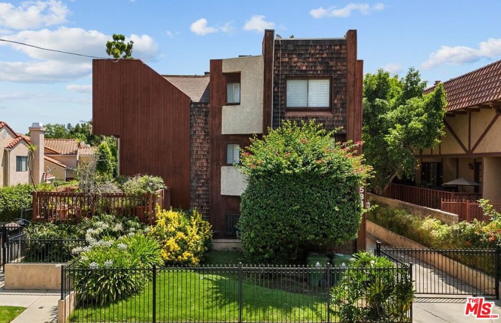 Experience the spaciousness of a single-family home with the convenience of a townhouse in this rare tri-level residence located in the heart of Tarzana in a well maintained 4-unit building. Spanning over 2,400 square feet, this home offers a truly expansive living experience for families of all sizes. The recent updates, including newer windows and fresh interior paint, create a bright and welcoming ambiance. You'll appreciate the timeless character of the hardwood floors that flow through the main living areas. The generous living room, complete with a cozy fireplace, and an elegant formal dining area provide the perfect setting for both everyday living and entertaining. The large eat-in galley kitchen, with its ample counter space and modern appliances, is ready to handle any culinary adventure. With four spacious bedrooms and four full bathrooms, there's plenty of room for everyone. The updated restrooms feature newer paint, newer vanities, and newer fixtures. A flexible bonus room on the main floor can easily function as an office, study, playroom, or even a fifth bedroom. The expansive primary suite is a private sanctuary, boasting a double-door entry, mountain views, a spa jetted tub, separate shower and abundant of closet space, with walk-in closets. The other oversized bedrooms also offer generous storage. Downstairs, a private in-law suite with its own entrance and bathroom provides an ideal space for guests, extended family, or an income producing option with direct access to the two-car garage. Imagine spending your weekends relaxing by the sun-drenched pool or hosting unforgettable get-togethers in the spacious entertainment area, perfect for friends and family. This home is designed for a dynamic lifestyle, placing you just minutes away from everything you need. You'll find yourself close to top-rated schools, a variety of local businesses, and a short walk from Trader Joe's and the popular Ventura Boulevard. Commuting is a breeze with easy access to the 101 freeway. This isn't just a home; it's an opportunity to embrace a lifestyle that offers the best of both worlds, peaceful living with the vibrant valley at your fingertips in one of the most sought-after neighborhoods.