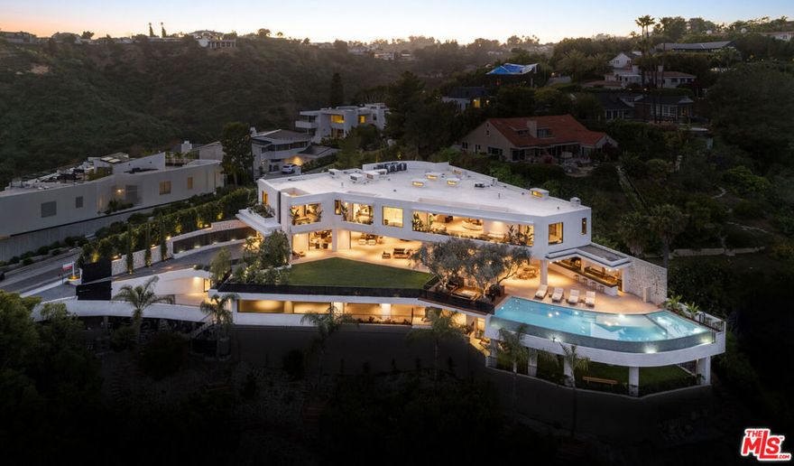 Welcome to 1050 Stradella Road, a brand-new construction nestled in the prestigious neighborhood of Bel Air. Boasting unparalleled craftsmanship and meticulous attention to detail by David Maman Design, this 7-bedroom, approximately 16,000-square-foot residence redefines contemporary luxury living. Inside, find a world of sophistication, with custom finishes and top-of-the-line appliances throughout.  As you enter through the enormous custom wood door you'll find the well-appointed office, open space living and dining areas with access to the large outdoor grassy area. There's an adjacent lounge and bar off of the dining area to entertain guests.  The chef's kitchen boasts a large center island with limestone countertops, Brazilian wood cabinetry, Miele appliances, and a butler's pantry with Wolfe double ovens and a walk-in refrigerator and freezer. You can entertain in the family room, formal dining room, or living room all of which have Fleetwood doors that slide seamlessly into the home with access to the outdoor kitchen, dining, infinity edge pool, and multiple covered outdoor areas including the lounge between the pool and grass which is graced with mature, imported olive trees. The lower level features a theater, wine room, and bar/lounge area looking out to a see-through glass feature to the infinity pool and a second outdoor multipurpose area. A wellness room offers hot and cold plunges, a sauna, a steam shower, and a massage area. Enjoy panoramic views from multiple outdoor areas including a full outdoor kitchen and Zen garden. The primary suite boasts a balcony, dual bathrooms, dual walk-in closets, a wet bar, and views of the ocean.  Six additional en-suite bedrooms, a dedicated office, a gym with canyon views, an elevator, double gated entry with access to motor court and garage parking for up to 8 vehicles, a cigar room with a ventilation system, and guards room complete this remarkable estate. Situated in Upper Bel Air, this residence offers proximity to elite dining, hiking trails, and renowned amenities. With its unparalleled design, state-of-the-art features, and prime location, 1050 Stradella Road presents a rare opportunity to experience the epitome of luxury living in Los Angeles.
