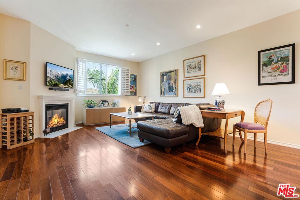 Experience light-filled living and elevated views in this top-floor, two-story Serenade home in Playa Vista. With its open layout, flexible living spaces, 2 balconies, and serene views over the bluffs and treetops, this beautiful residence offers a rare opportunity in one of the community's most desirable buildings. The main level features a welcoming great room with hardwood flooring, a cozy fireplace, and solar tube lighting that adds natural light throughout the day. Just off the entry is a versatile flex space- ideal for a home office, play area, or creative retreat. The kitchen includes bright white cabinetry, stainless steel appliances, bar seating, and generous storage, and overlooks the dining area and outdoor patio - perfect for everyday living or entertaining. Downstairs, you'll find two spacious bedrooms, including the primary suite with its own private balcony, dual walk-in closets, and a well-appointed ensuite bath. The second bedroom offers a large closet and easy access to a full bathroom, with a convenient laundry area also located on this level. Additional highlights include two side-by-side parking spaces in the gated garage, with an EV charging station conveniently located between the two side-by-side parking spaces, as well as balcony storage. Located just across the street from Concert Park and the surrounding shops and restaurants. Enjoy the best of Playa Vista living with close proximity to the Centerpointe Club, The Resort, Runway's retail and dining, Whole Foods, Cinemark, Playa Vista Elementary School, and all the amenities that make this Silicon Beach community so special.