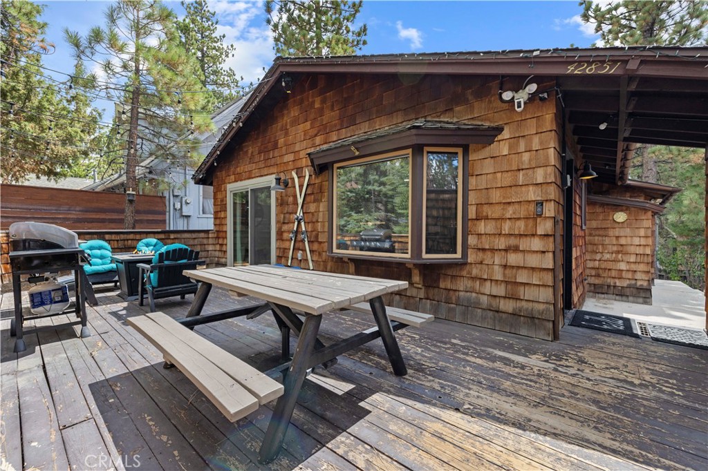 This Moonridge retreat is the mountain escape you have been waiting for, offering Big Bear living in every season. Nearly 1,000 sq ft with 2 bedrooms and 2 bathrooms, it is thoughtfully updated with LVP flooring throughout, fresh finishes, and a new smart ductless A/C in the living room to keep summer days refreshingly cool and winter nights cozy warm, easily controlled from your phone or the included remote. The kitchen opens to the living room where a stunning rock fireplace with a wood burning stove insert anchors a welcoming gathering space. The large front yard boasts a private playground and plenty of room for sledding and snow play in the winter, your own personal winter wonderland, a rare luxury in Big Bear. The front deck is perfect for grilling and entertaining with an included BBQ grill and fire pit. The guest bedroom enjoys a private back deck to take in sweeping views of Snow Summit, Bear Mountain, and the surrounding peaks. The guest bathroom includes a shower in tub combination and a large frameless anti fog LED light wall bathroom vanity mirror. The spacious primary bedroom offers a private bathroom with a walk in shower, dual sinks, and in home laundry for convenience. Centrally located between Bear Mountain Resort, Snow Summit Resort, Bear Mountain Golf Course, The Village, the lake, and a multitude of restaurants, groceries, shopping, and amusement attractions, there is always something to do for all ages. Whether it is skiing and snowboarding in winter, hiking and biking in spring, golfing and lake days in summer, or crisp autumn nights under the stars, this home delivers year round adventure and memorable mountain living. This turnkey property offers both lifestyle enjoyment and income potential, and it also has a proven track record as a short term rental for those seeking a turnkey Airbnb opportunity.