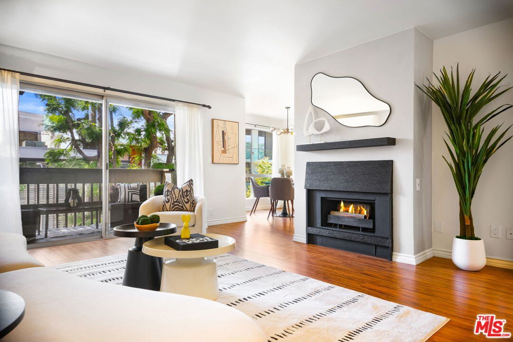Nestled in the highly coveted Norma Triangle, right on the border of Beverly Hills and West Hollywood, this TOP-FLOOR 2-bedroom, 2-bath condo is a sleek, modern retreat in the heart of it all! Offering 1,054 sq. ft. of stylish living space and two coveted side-by-side parking spaces, this rare find combines an ideal floor plan with elevated finishes. Two spacious bedrooms sit on opposite sides of the home, each with its own updated ensuite bath for the ultimate in privacy perfect for roommates, guests, or a home office setup. Floor-to-ceiling windows illuminate the space with warm southern light, highlighting gleaming laminate and tile floors while framing peaceful treetop views. The inviting living room flows seamlessly to a private balcony wrapped in greenery, with a striking black fireplace and lime-wash accent wall adding a dramatic focal point. A sunlit dining area, accented by a chic new chandelier, opens to the gourmet kitchen - complete with brand-new cabinetry (with built-in trash and recycling), quartz countertops, stainless steel appliances including a double-door fridge, and a vented gas cooktop that makes both cooking and entertaining a breeze. Each bathroom has been tastefully renovated with new vanities, LED smart mirrors, and modern fixtures. Dual-zone, energy-efficient split A/C and heating ensure year-round comfort. All of this is set just moments from world-class dining, designer boutiques, markets, Melrose, Sunset Plaza, Soho House, the Pacific Design Center, and major studios - yet tucked away on a quiet, tree-lined street that feels worlds apart from the city bustle. HOA allows in-unit washer/dryer installation with approval - please inquire for details.