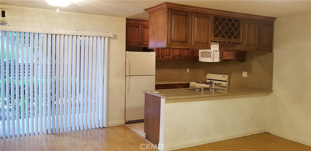 Conveniently located on the first floor, this unit offers easy access to the pool, recreation room, and BBQ area. The open floor plan includes a kitchen with wood cabinetry, granite countertops, and laminate wood flooring throughout. Ample storage with multiple closets, plus a designer vanity in the bathroom. The living room features an additional air conditioning unit for added comfort. Enjoy quick access to the freeway, restaurants, and shopping. A great entry point for first-time buyers or a smart investment opportunity. You’ll love it!