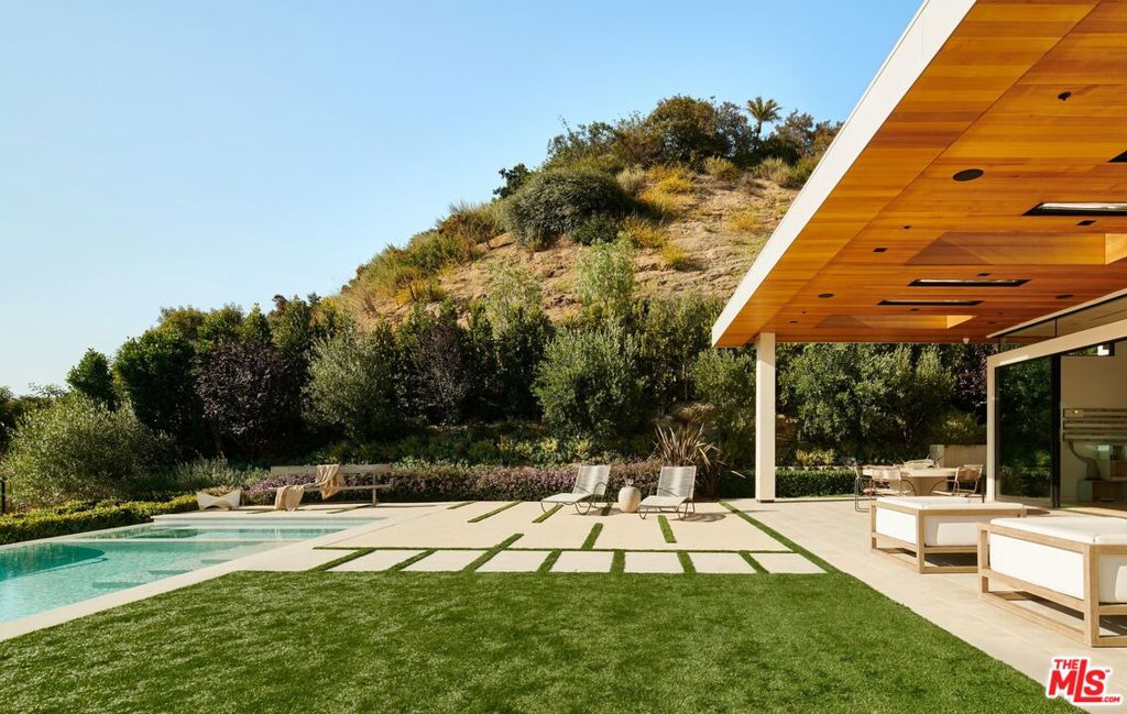 Located in the highly sought-after Trousdale Estates, this 2021-built, modern home represents a strategic investment in both lifestyle and lasting value. The property is situated on a flat lot, offering expansive and unobstructed views of the surrounding mountains. The design is a testament to modern Californian architecture, blending functionality with aesthetic appeal. Warm, natural interiors shape the space, with materials that emphasize comfort. The property's location in Trousdale Estates positions it in one of the most prestigious and resilient real estate markets, known for consistent demand and enduring value.