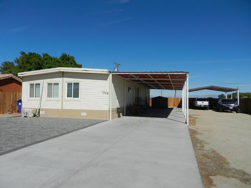 Like brand new and more. This manufactured home has been completely remodel, with new flooring, kitchen, updated bathrooms, new paint in and outside, with a 56' concrete floor covered patio/car-port for either keep your car/s out of the sun or guest those family and friends gatherings. Also chain link gate, pavers installed at front yard and two sheds one for your laundry and the other for your tools or as an extra storage. Wait no more and make it yours now.