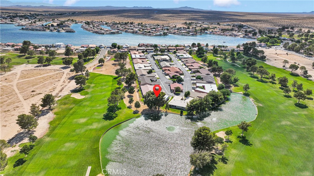 You’re in luck! The condo with the BEST view in Silver Lakes is now available. This resort community includes an abundance of amenities. This particular unit is an end unit with an unobstructed view of the pond, the golf course and mature shade trees. It also enjoys the serenity of the sound of the water feature. The covered patio overlooks this impressive and serene setting. The interior is designed to bring the impressive view indoors with large windows outfitted with custom remote operated cellular shades. The view is panoramic. This home’s upgraded interior includes vinyl wood-look flooring, granite counters, upgraded lighting and fixtures. Stone hearth fireplace in the living room. Large dining area perfect for entertaining. Open floor plan accommodates a large sofa suite. Split floor plan for the enjoyment of privacy. The primary bedroom suite overlooks the green landscape and water as well. Indoor laundry with storage in a separate room. This home is built for every day enjoyment, or as a peaceful vacation destination. Want golf? Swimming? Parks? Fishing? Well, Silver Lakes HOA and the Fairway Court condo association offer all of that included! The finished garage includes a workshop/hobby area, walk-up attic access; space for your golf carts bikes, water toys, and more. This home is ready to go as a vacation getaway with great proximity to Los Angeles, and the Ontario International Airport. Silver Lakes in Helendale, CA is an oasis. The picturesque, well-maintained master planned community offers a lifestyle where you can vacation where you live. Come see what awaits in this gem of a setting. This is a rare find with a breathtaking setting.