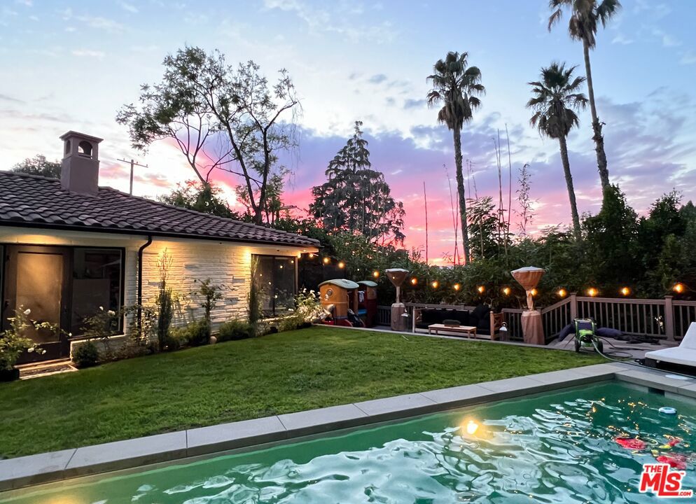 Tucked away at the end of a quiet cul-de-sac in one of Sherman Oaks' most coveted leafy neighborhoods, this tastefully remodeled single-story pool home delivers the best of California resort-style living just moments from Ventura Boulevard. Step inside the 3 bed, 2.5 bath residence (approx. 2,109 sq ft) and you're welcomed by a clean, modern aesthetic with rich 9.5" wide-plank engineered Oak hardwood floors, recessed lighting throughout, and hand-applied Portola Roman Clay finishes that add texture and warmth to key living spaces. At the heart of the home is a show stopping 7ft x 5ft waterfall-edge island anchoring the fully custom kitchen complete with a food prep sink, Oak cabinetry on both sides, pot filler, and top-tier appliances including a 36" Thermador 6-burner gas range, Samsung refrigerator, and dishwasher. Perfect for those who love to cook and entertain. The primary suite overlooks the private, lush backyard and it's oversized 40-ft heated lap pool 10 ft deep at one end framed by sun decks, grassy space, and golden hour valley views. Bedroom 3 includes a private en-suite with shower and stunning Roman Clay walls, ideal for guests or a luxe home office setup. Additional highlights include a brand-new 15-panel solar system (for reduced utility costs), included sun loungers and outdoor heaters, and proximity to the best of the Valley just a 10-minute walk or 2-minute drive to hotspots like Steak Blvd, Tashio, Westfield Fashion Square, Equinox, SO Galleria, boutique spas, and more. This is elevated Sherman Oaks living, effortless, stylish, and completely private. Available fully furnished and turnkey for short, midterm, or long term lease.