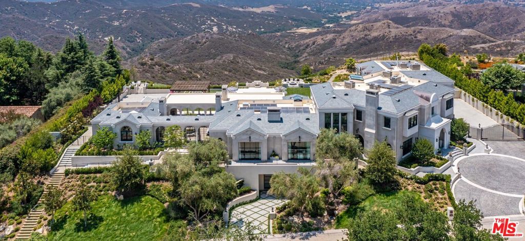 Perched in the prestigious double-gated Estates at The Oaks of Calabasas is this newly constructed magnificent modern French provincial estate. Spread over 1.65 Acres the home has countless custom features and finishes including antique wood beams adorning the ceilings paneled walls & stately millwork and wide-plank walnut wenge & oak floors throughout. The double-height foyer leads you to an open and airy interior with high ceilings and sensational details. An elegant great room faces a magnificent chefs kitchen complete with an inviting eat-in nook. Expansive accordion doors open to an outdoor oasis with an oversized pool/spa sports court lush lawns serene atrium & goldfish pond rose garden conservatory pergolas firepit & a charming orchard & vegetable garden. An exquisite primary suite with an expansive view off the private balcony features a luxurious bathroom with Borghini marble and custom vanities. The subterranean level features a 15-seat theater wine cellar and a rare 9+ car garage with a street entrance. This extraordinary home is at the pinnacle of prestige & lifestyle with breathtaking views of the serene Santa Monica Mountains.