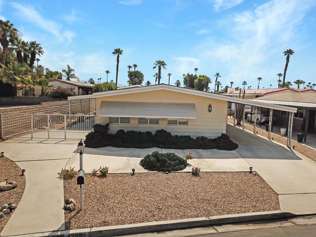 Come an Enjoy the Lifestyle at Portola Club where you can Play Golf on the 18 Hole, Par 3 Course, Swim in the Three Pools & Spas, Play Pickle Ball or Tennis, or just Walk your Dog to the Dog Park or Pond! This 55+ Gated Community has so Much to Offer! This Beautiful Home is located Directly Next to the Clubhouse with Many Activities with a Pub, Billiard Room, Library and a Large Dining Facility. The Primary Bedroom is located at the rear of the home for Ultimate Privacy, Spacious Closet, complete with En Suite Bath. The Guest Bedroom also has an Attached Full Bath. An Updated Kitchen Features Granite Counters, Oak Cabinetry, Newer Appliances and Casual Bar Top Dining, all Open to the Great Room. A Formal Living and Dining Room Showcases Tastefully Appointed Interior Spaces that Bask in the Natural Light. There is a Two Car Covered Carport with a door leading into The Laundry Room that can double as an Office or Hobby Room. The Exterior Patio faces North with Partial Mountain Views. Come joint the fun at Portola CC with low HOA of $440 per month which includes FREE Golf, Cable & Wifi, Trash and a Calendar full of Events and Activities. This is one of the few Country Clubs where You OWN the LAND!