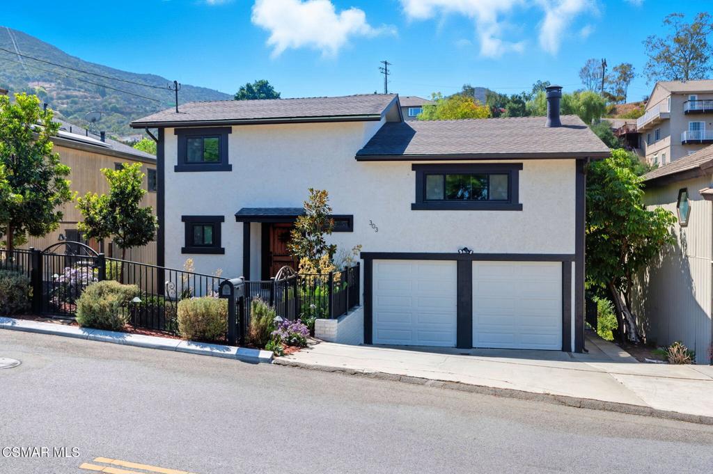 Welcome to 303 S Ventu Park Rd, a tranquil tri-level retreat in the coveted Ventu Park area of Newbury Park, Thousand Oaks. This 1,356-square-foot home features 2 bedrooms and 2 bathrooms, offering a harmonious blend of comfort and natural beauty. Nestled above a lush tree canopy, the property boasts breathtaking mountain views from every window. The open-concept main living area is highlighted by vaulted wood ceilings, a cozy fireplace, and expansive windows that fill the space with natural light. The kitchen is equipped with quartz countertops, a tile backsplash, and stainless steel appliances, making it a chef's delight. The top-level master suite offers a private deck, a large walk-in closet currently used as a home office, and an en-suite bathroom with a walk-in shower. The lower level houses a spacious second bedroom and a full bathroom. Additional features include a dedicated laundry room and a two-car garage with built-in storage. Enjoy the serene outdoor spaces, including a secluded seating area accessible via private stairs, where you can relax to the sounds of a nearby creek. This property is a perfect private retreat, offering a lifestyle that seamlessly blends tranquility with modern living.