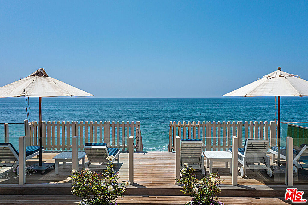 On the market for the first time in over 20 years, this beachfront hideaway boasts beautiful natural light, an open concept, ocean views and a rich Hollywood history. Make your way through the 24-hour guarded gate of Malibu Colony to find a charming tri-level home with warm hardwood and interiors by famed White House designer Michael Smith. Ready for cooking and entertaining, the kitchen features an island, Wolf range and two sinks. The adjacent living room abounds with architectural details, including built-in arched bookshelves. A wall of French doors opens to a sunny deck for easy indoor/outdoor living. Enjoy a built-in barbecue and direct beach access. Upstairs, discover two primary suites overlooking the Pacific and additional bedrooms with mountain views. The two-car garage and driveway provide ample parking. Right in the heart of Malibu, youre only moments from highly desirable shopping and dining, including Nobu and SoHo House.