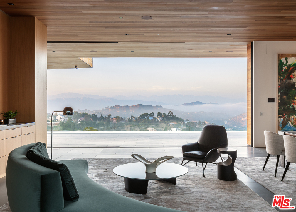 Escape to a world of utmost tranquility & seclusion, at the architectural marvel that is Carla House. Meticulously crafted by famed architect, Noah Walker, this masterpiece was impeccably designed to frame the awe-inspiring from Griffith to the Hollywood sign w/2 wings anchoring a 2,000SF rooftop deck. In Trousdale Estates, this one-of-a-kind home spans approx. 20,000SF on 1.2 acres. Open floorplan is accented by disappearing walls of glass for indoor/outdoor living. Gourmet kitchen w/dual marble islands, wine cellar, white oak cabinetry & Gaggenau ss appliances. Lux master w/leather wall, lounge, balcony, decadent bath, rain shower, soaker tub, skylight, dual closets w/extensive built-ins & vanity. Features include movie theater, fitness studio, wellness center, office, elevator, service kitchen, maid's quarters, 5+ car garage & more. Main level deck w/impressive 80ft pool, spaces for lounging/dining al fresco, outdoor kitchen & green jetty centered by a contemporary fire feature.
