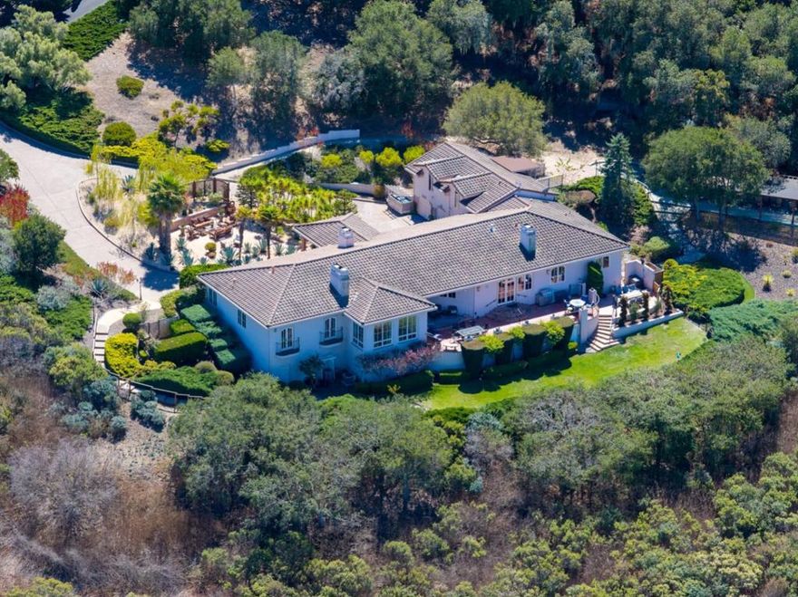 Perched atop one of Bay Ridges premier ocean-view parcels, this Mediterranean-inspired estate captures sweeping vistas of the Monterey Bay, Pasadera Country Club, city lights, and rolling hills. Set on over three private acres, the home offers both serenity and sophistication in a coveted gated community. A graceful portico entry sets the tone for the interiors, where 10-foot ceilings, custom arched French doors, and expansive windows flood the home with natural light while framing unforgettable views. The residence includes 4 bedrooms, 4.5 baths, with a guest quarter above the three-car garage.   The gourmet kitchen opens seamlessly to a sunny terrace, ideal for indoor-outdoor living and entertaining. The beautifully landscaped grounds feature mature trees and multiple patio spaces, thoughtfully designed for quiet reflection or gathering with friends. Exceptional craftsmanship and timeless design define this home, making it a rare opportunity to experience the very best of California coastal living.