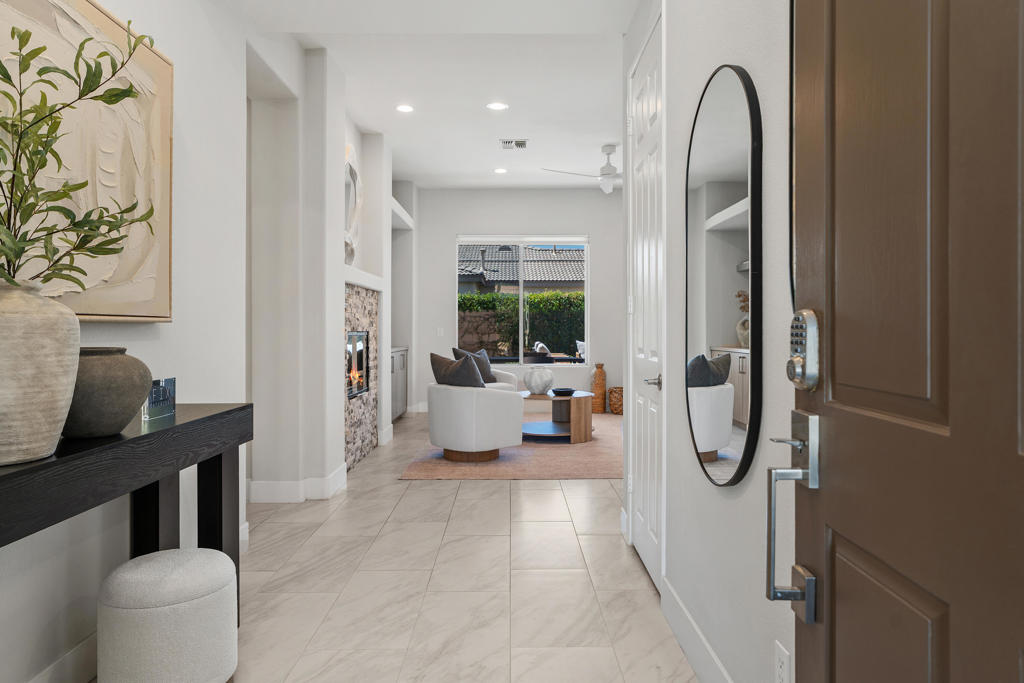 Stylish, Spacious, and Exceptionally Upgraded! Beautifully remodeled in 2022 with contemporary finishes, this four-bedroom, three-bath home in the gated Aldea community offers the perfect blend of modern design and thoughtful functionality. Situated on a private corner lot, the home features porcelain tile flooring throughout, custom tile finishes in the bathrooms, and an open-concept layout filled with natural light. Enter through a formal entry into the expansive great room, where a stone fireplace and custom built-in cabinetry create a warm and inviting focal point. The space flows seamlessly into a chef's kitchen that will delight cooks and entertainers alike, with shaker-style cabinetry, waterfall-edge quartz countertops, and stainless steel appliances. The spacious primary suite offers direct access to the pool and a luxurious bath with dual sinks, an oversized glass tile shower with bench seating, and a large walk-in closet with custom built-ins. Three additional bedrooms provide flexibility--one with its own ensuite bath, ideal for guests, and another currently staged as a home office. A well-appointed laundry room includes quartz counters, built-in cabinetry, and a utility sink for added convenience. Step outside to your private desert oasis featuring a sparkling pool, spa, built-in barbecue, and a tiled outdoor shower--perfect for enjoying the indoor-outdoor lifestyle. Additional upgrades include newer HVAC, window treatments, and appliances. With low HOA dues and a prime location near shopping, dining, entertainment, Palm Springs International Airport, downtown Palm Springs, and Mission Hills Country Club, this move-in-ready home offers both luxury and lifestyle--with room to grow.