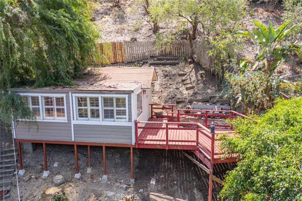 Often referred to as the Laguna Canyon Treehouse, this unique home offers a rare retreat surrounded by panoramic canyon and hillside views. Tucked away in a secluded setting, the property features laminate flooring throughout, plantation shutters, beamed ceilings, a well-appointed kitchen, and a clean, updated bathroom. The bedroom is cozy in size but offers generous closet space. While there are steps leading up to the home, the spacious deck and sweeping views make the journey well worth it. Utilities including water, trash, gas, and electric are all included. Convenient open parking is available directly across the street.