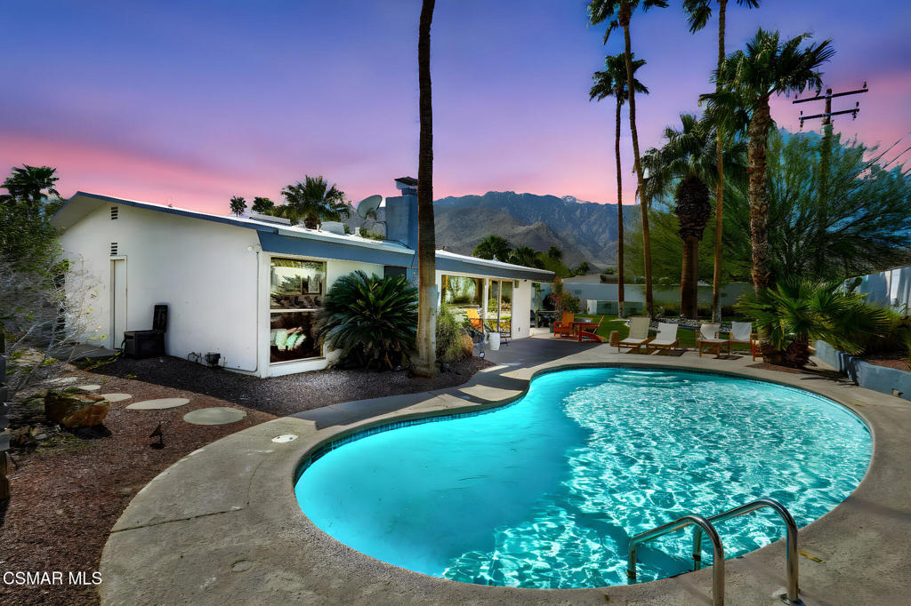 Welcome to 1102 E Adobe Way, a beautifully reimagined mid-century modern Alexander home located in the highly coveted Racquet Club Estates of Palm Springs. This 3-bed, 2-bath retreat seamlessly blends modern amenities with timeless mid-century charm, offering the ultimate in style, comfort, and investment potential.Step inside and experience your own private retreat where indoor and outdoor living harmonize perfectly. The recently remodeled open kitchen, complete with quartz countertops, modern appliances, a center island, and built-in wine fridge, overlooks the spacious dining and living areas. Floor-to-ceiling walls of glass frame the resort-like backyard, bringing in natural light and offering breathtaking views of the lush landscape and sparkling heated pool. Whether you're entertaining or enjoying quiet moments, this space feels both open and comfy.The primary bedroom is a dream, featuring a stunning en-suite bathroom and private patio for morning coffee or evening relaxation. Outside, a fully fenced backyard oasis awaits, complete with a cozy raised firepit area, extensive seating, and enchanting mountain views. Multiple fruit trees adorn the property, while a newly installed sprinkler system keeps the landscaping vibrant year-round.For convenience and peace of mind, the home boasts all-new technology, including a WIFI doorknob with keypad access, a newly installed alarm system with cameras, and four mounted state-of-the-art TVs (included in the sale). Additional features include an updated HVAC system, new electrical wiring, a newly installed washer and dryer, and an attached two-car garage with extra storage cabinets.As a unique bonus, all furnishings and decor - including brand-new bed linens, towels, cleaning supplies, yard games, pool accessories, and an arcade basketball game - are included at no cost, making this home truly turnkey.With no HOA, 1102 E Adobe Way offers fantastic potential as a rental property or vacation home (think Airbnb). Its prime location in Racquet Club Estates, combined with its proximity to acclaimed shopping, dining, and entertainment, makes it an attractive option for those looking to generate rental income while enjoying everything Palm Springs has to offer.