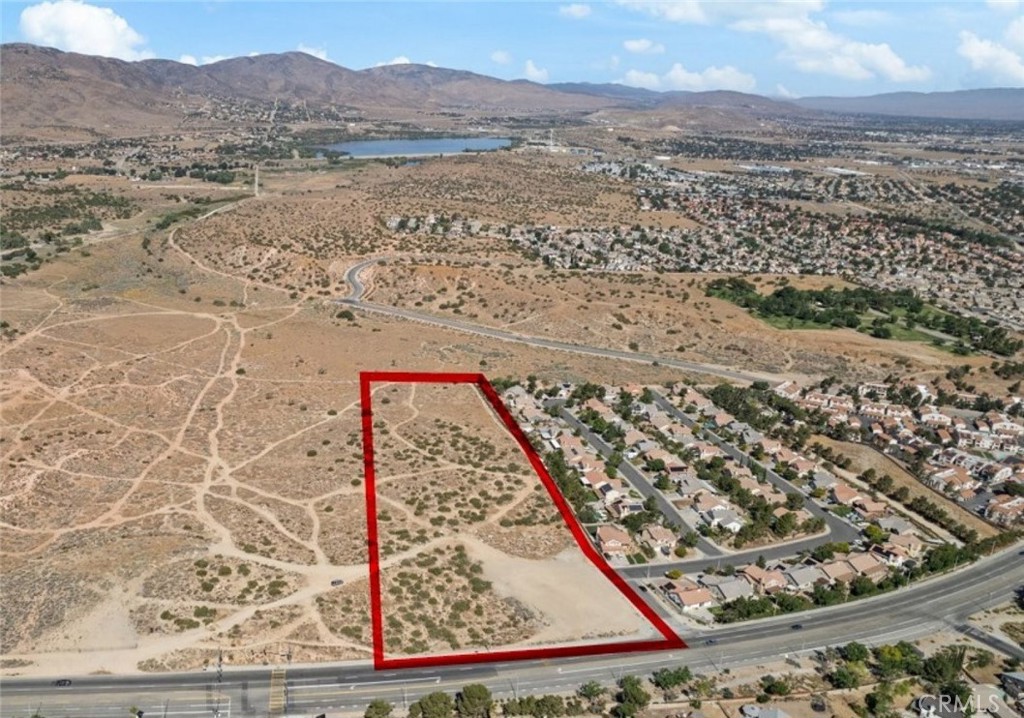 Now available in the heart of Palmdale, this expansive parcel spans approximately 416,180 square feet, over 9.5 acres of versatile, open land. Ideally situated on a signalized corner with multiple access points and high visibility from major thoroughfares, this lot presents a rare opportunity for development in a well-established residential neighborhood. With surrounding utilities nearby and residential tracts adjacent on multiple sides, this parcel holds incredible potential for subdivision, a custom estate, or a multi-phase residential project. Located just minutes from shopping, schools, and transportation routes, this land offering combines location, scale, and flexibility in one of Palmdale’s most active corridors.